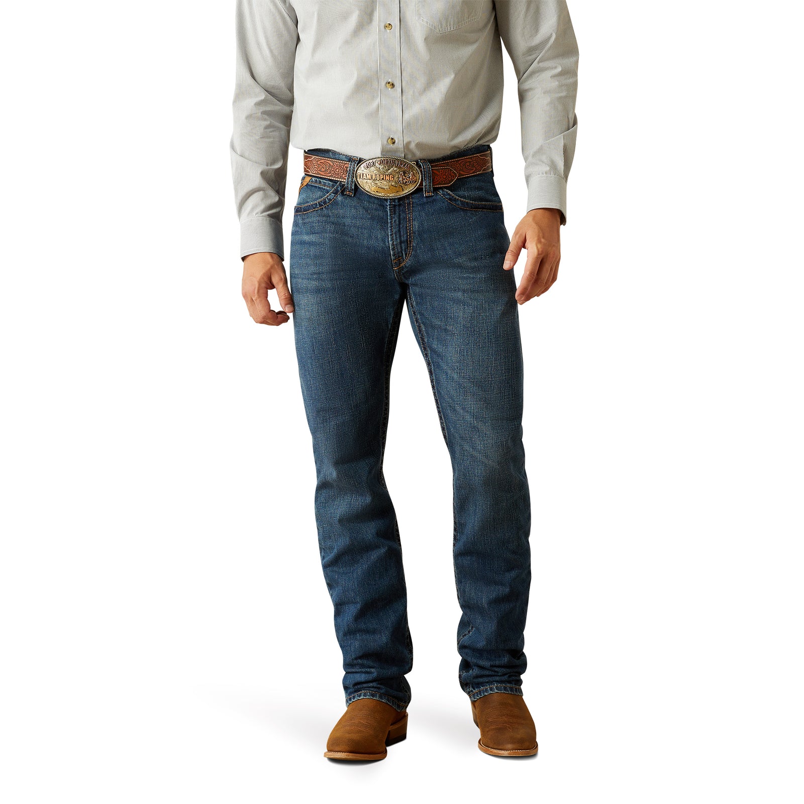 Ariat Men's M4 Norwich Relaxed Fit Jean. A man wearing a white shirt, blue jeans, and brown shoes.