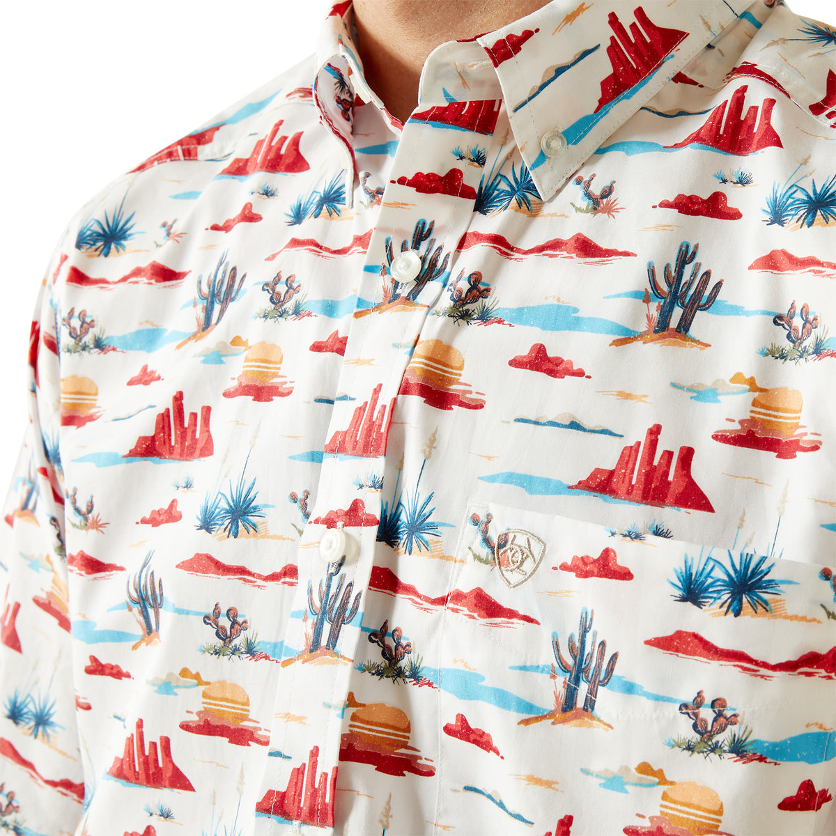 Ariat Men's Scout S/S Western Shirt. Close-up of a shirt with a colorful desert landscape pattern on a white background