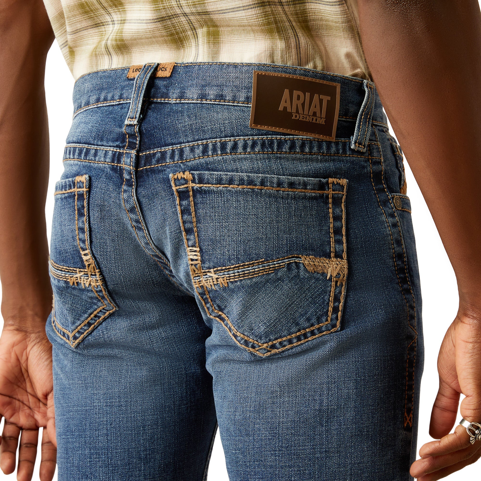Ariat Men's M7 Travis Straight Leg Jeans. Close-up of blue jeans with Ariat logo on a white background
