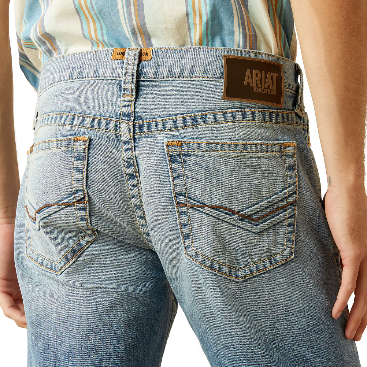 Ariat Men's M7 Tustin Slim Fit Straight Leg Jean. Close-up of blue jeans with Ariat logo on a white background