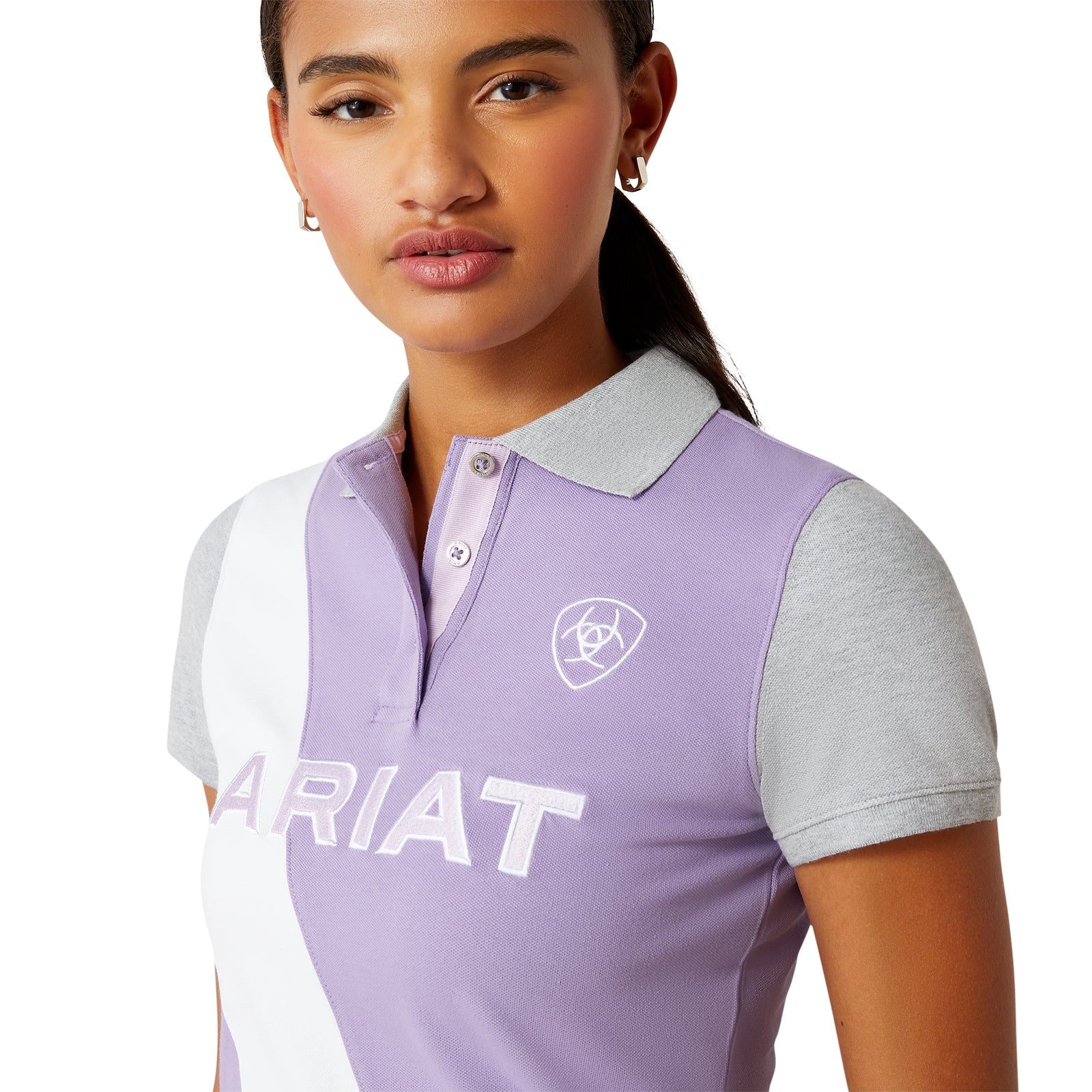 Ariat Women's Taryn Polo. Woman wearing a purple and white polo shirt with 'Ariat' branding on a white background