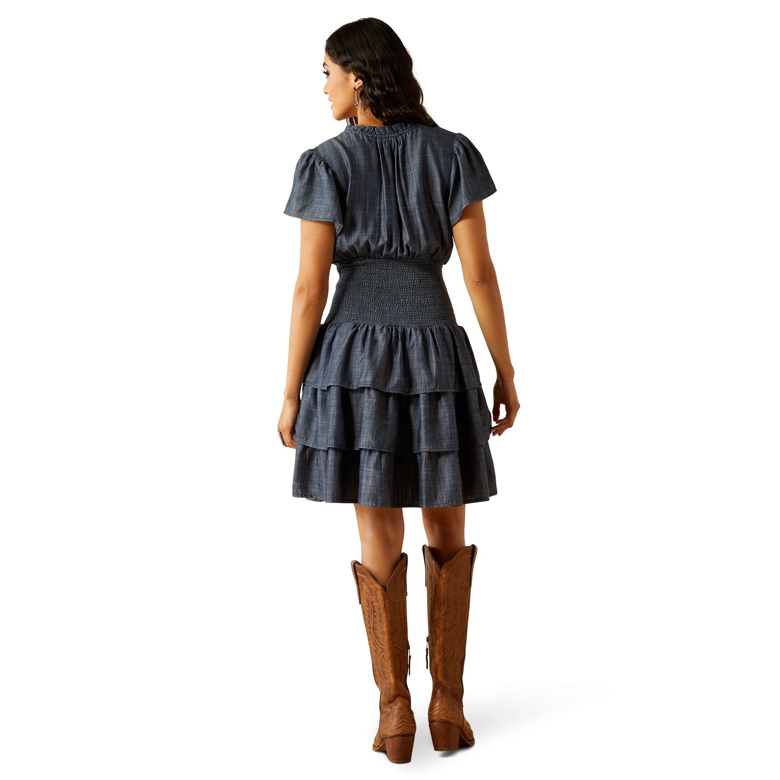 Ariat Women's Stellar Dress. Woman wearing a denim dress and brown boots on a white background