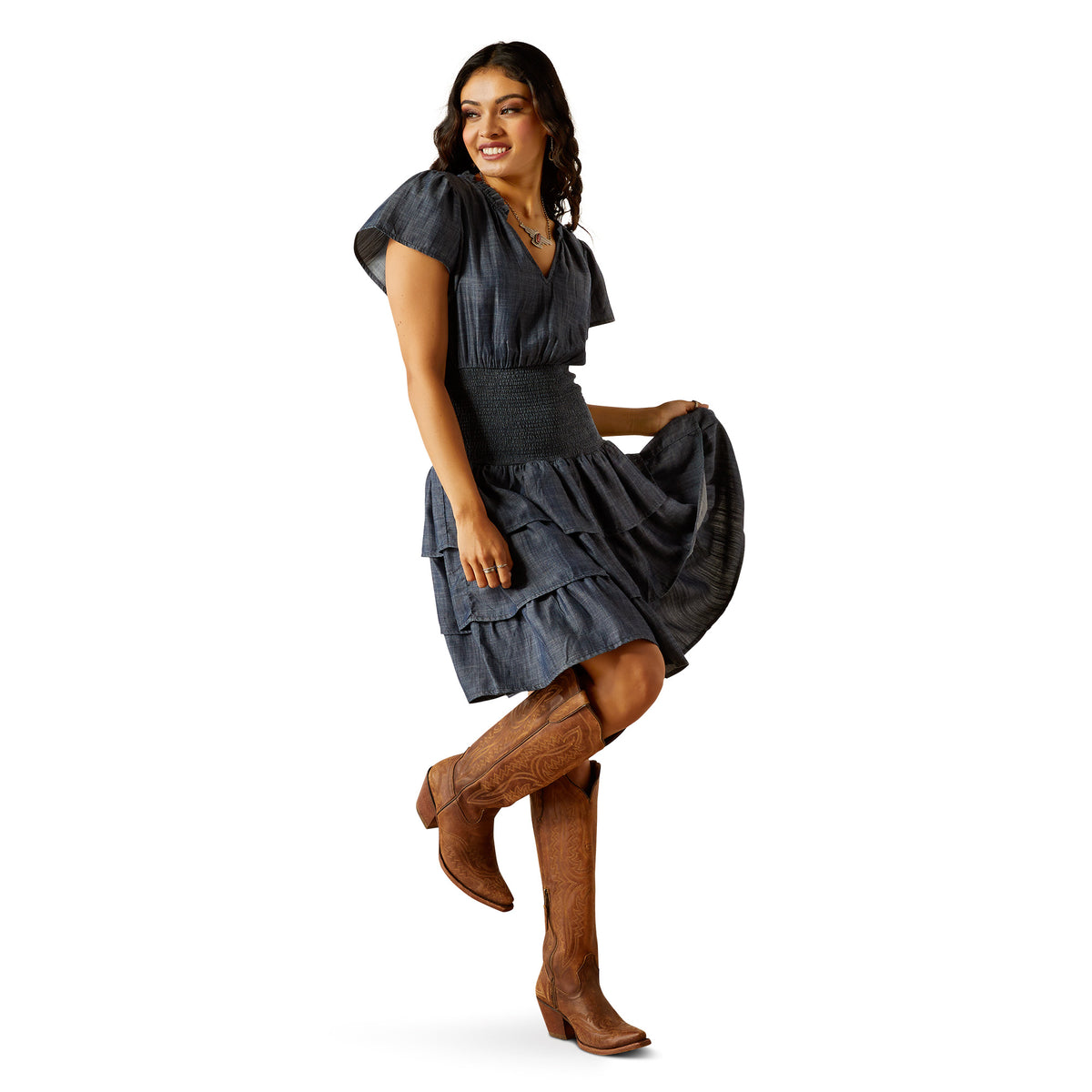 Ariat Women's Stellar Dress. Woman wearing a dark gray dress and brown knee-high boots on a white background