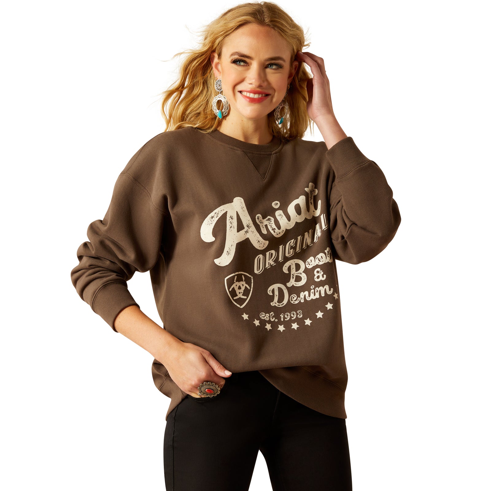 Ariat Women's Oversized Crew Sweatshirt. Woman wearing a brown sweatshirt with 'Ariat' branding on a white background
