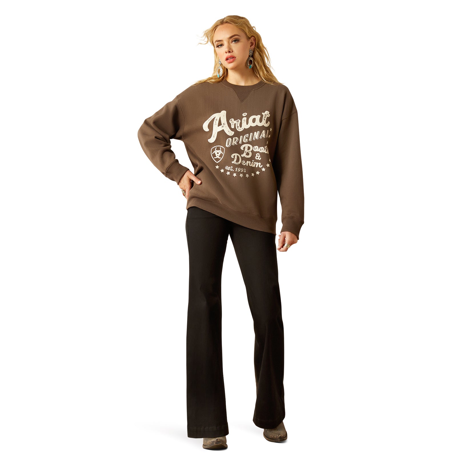 Ariat Women's Oversized Crew Sweatshirt. Woman wearing a brown sweatshirt with 'Ariat' branding on a white background