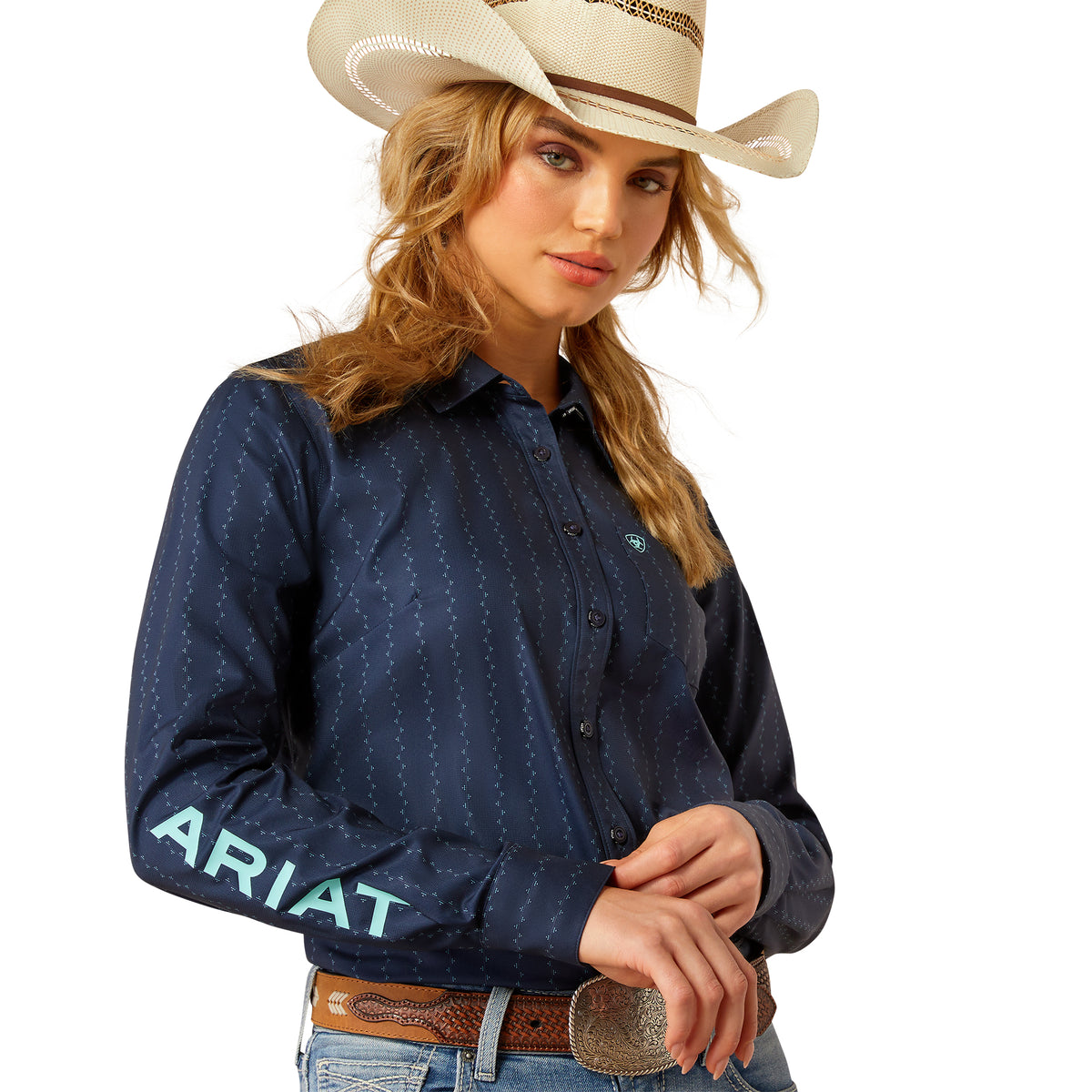 Ariat Women's Kirby Pro L/S Western Shirt. Woman wearing a navy blue Ariat shirt and cowboy hat on a white background
