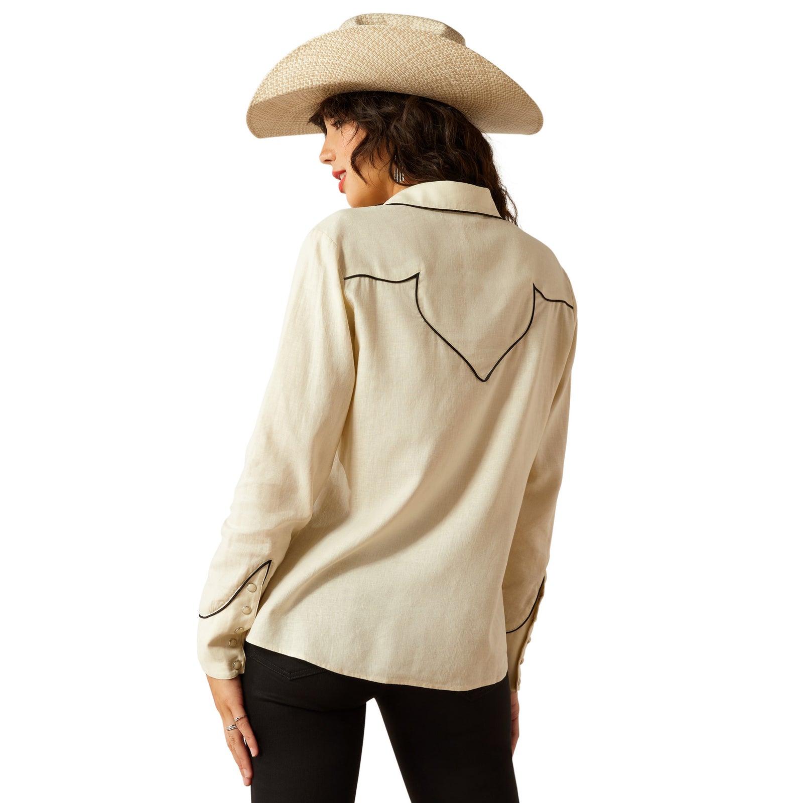 Ariat Women's Bluebell L/S Western Shirt. Woman wearing a beige button-up shirt and black pants with a straw hat on a white background
