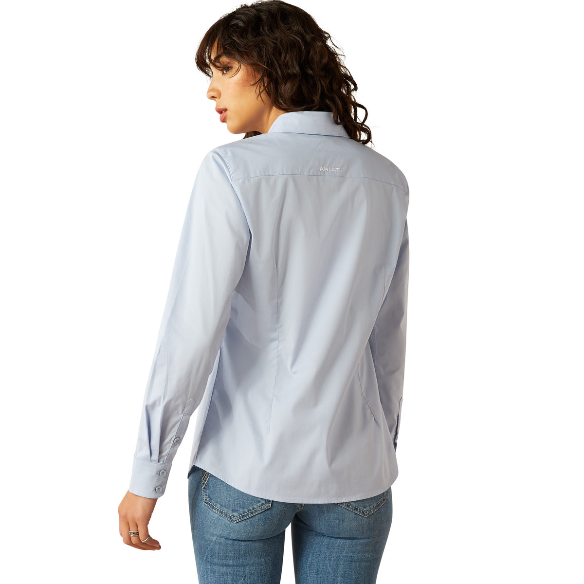 Ariat Women's Wrinkle Resistant Team Kirby Western Shirt. Person wearing a light blue shirt with a brand logo on a white background