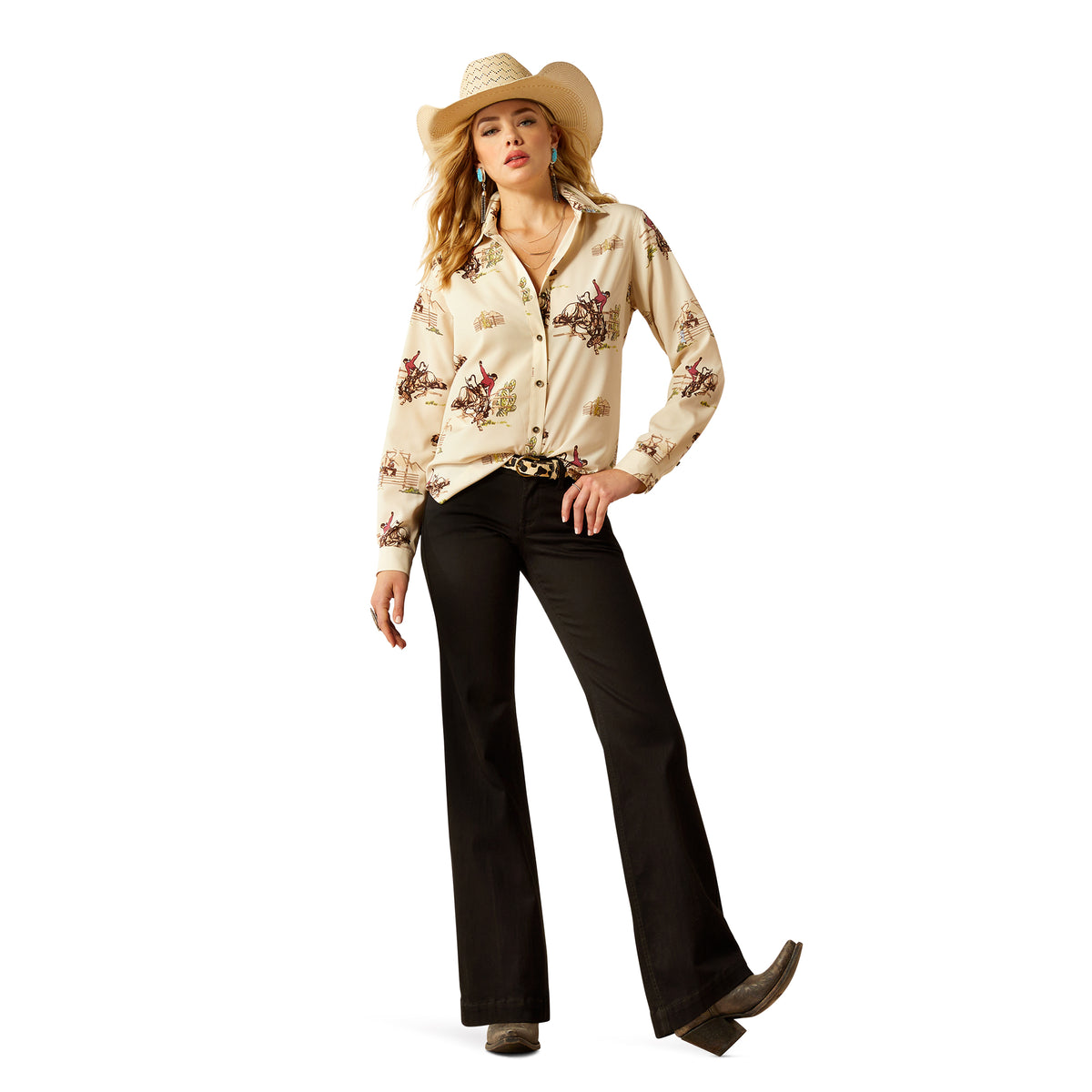 Ariat Women's Homestyle Button Up L/S Western Shirt. Woman wearing a floral blouse, black pants, and a cowboy hat on a white background