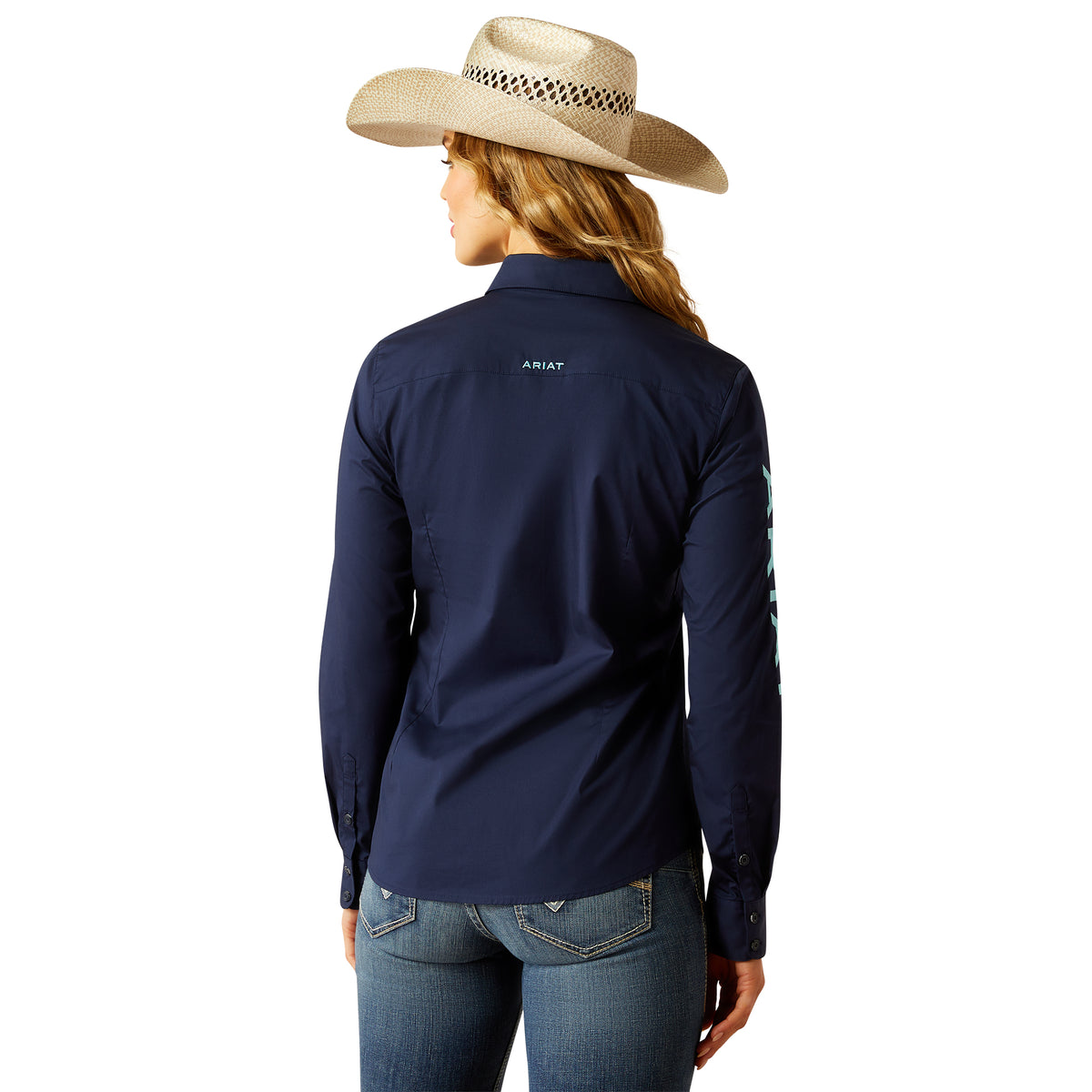 Ariat Women's Team Kirby Stretch L/S Western Shirt. Person wearing a navy Ariat shirt and straw hat on a white background
