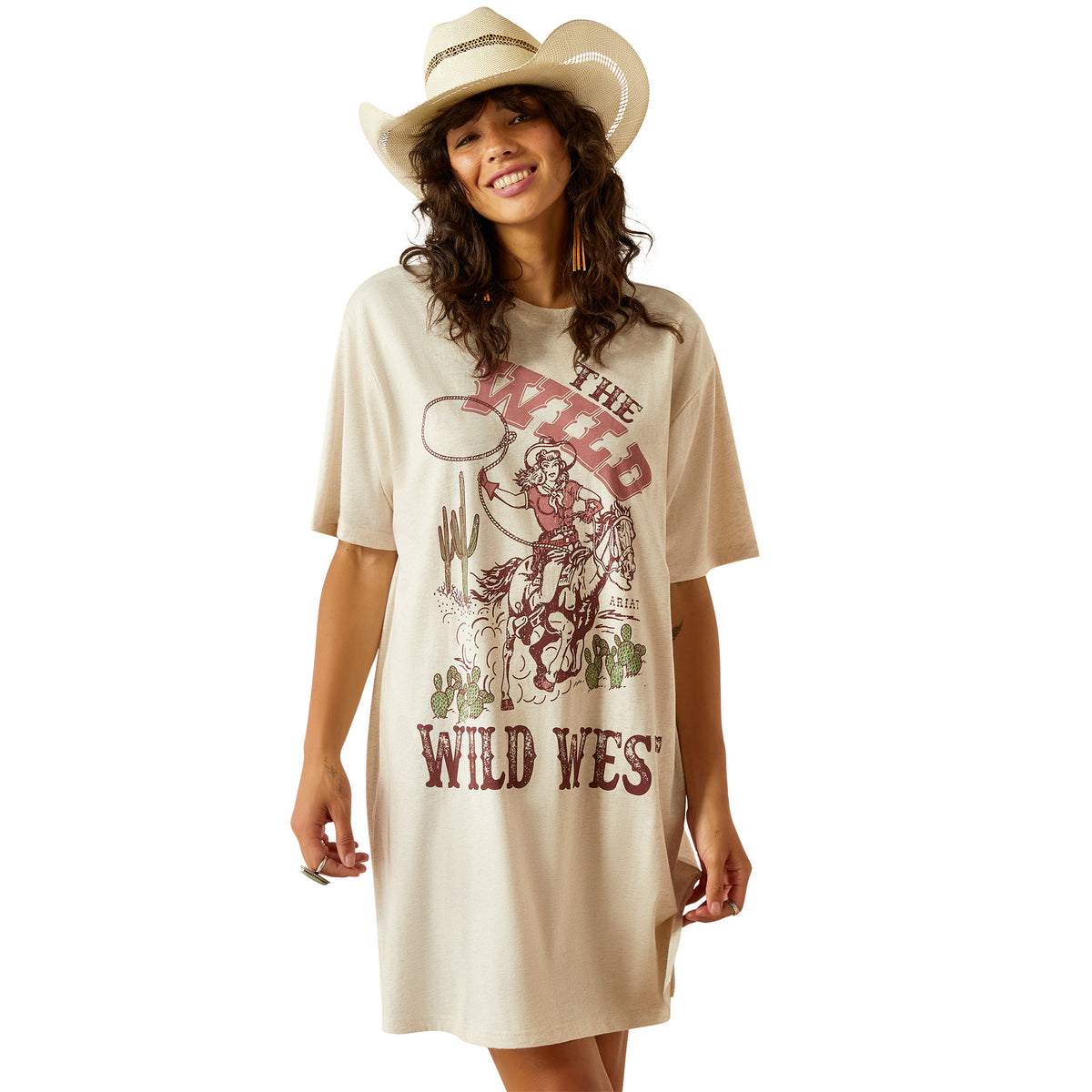Ariat Women&#39;s Wild Cowgirl T-Shirt Dress. Woman wearing a beige t-shirt with a graphic design and a cowboy hat on a white background