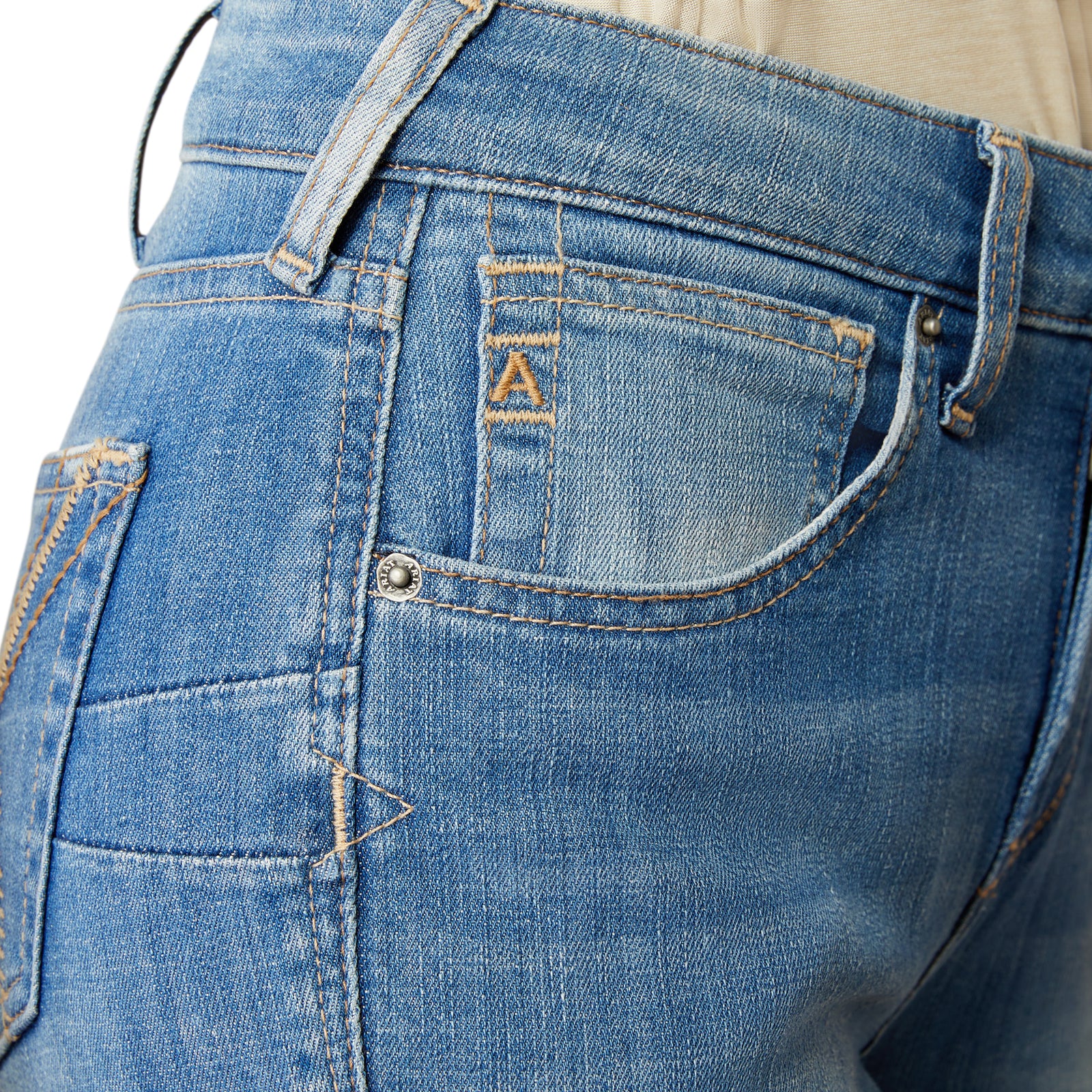 Ariat Women's Cassandra High Rise Boot Cut Jean. Close-up of blue jeans with a brand logo on the pocket against a white background