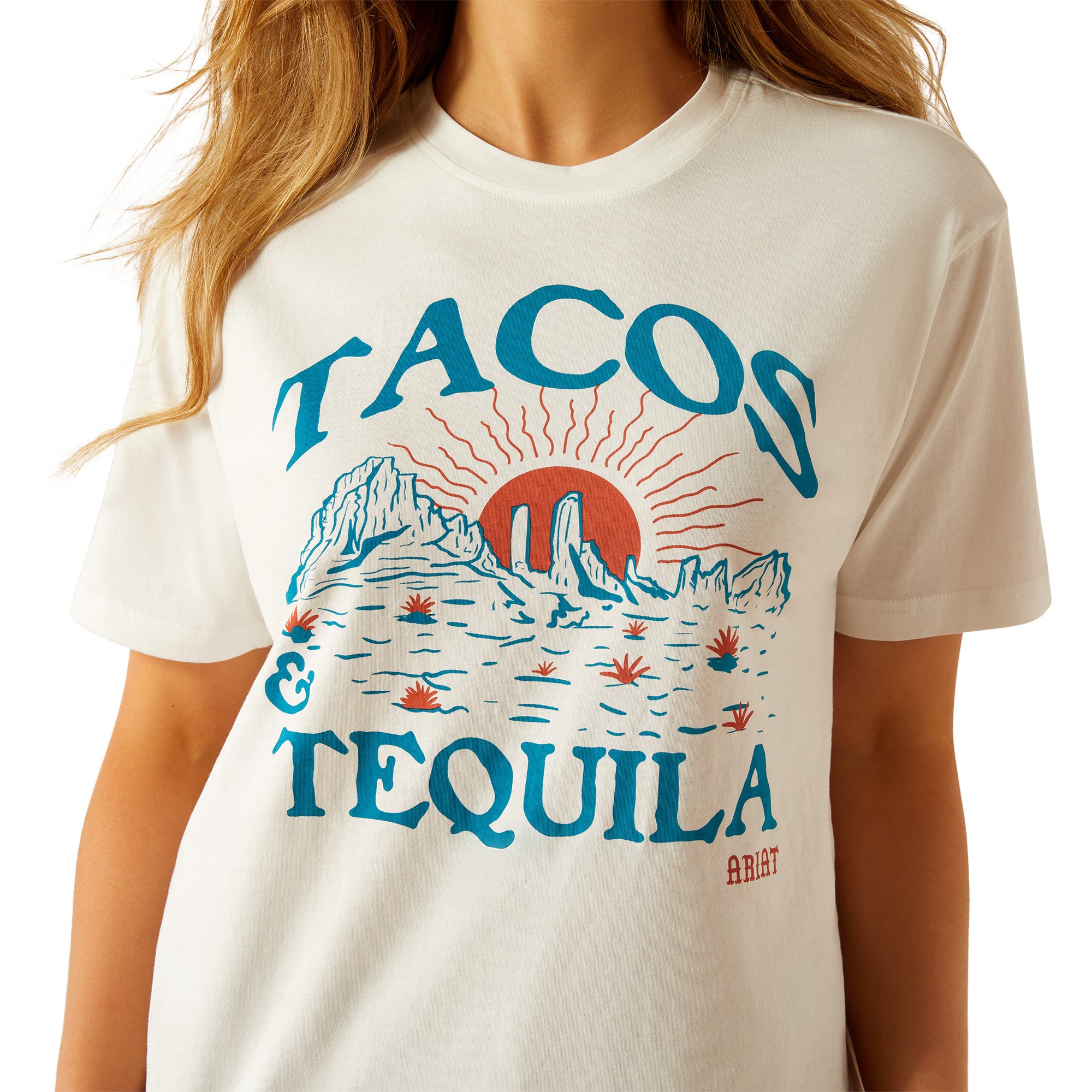 Ariat Women's Tacos and Tequila T-Shirt. Woman wearing a white t-shirt with 'Taco & Tequila' graphic design on a white background
