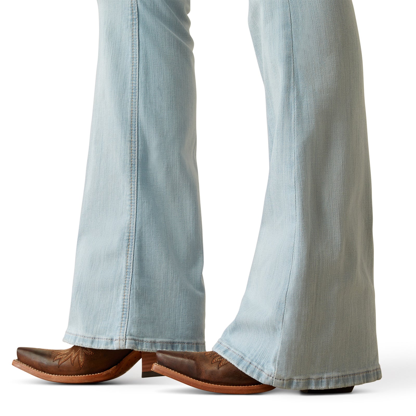 Ariat Women's June Perfect Rise Flare Jean. Light blue jeans worn by a person with brown cowboy boots on a white background