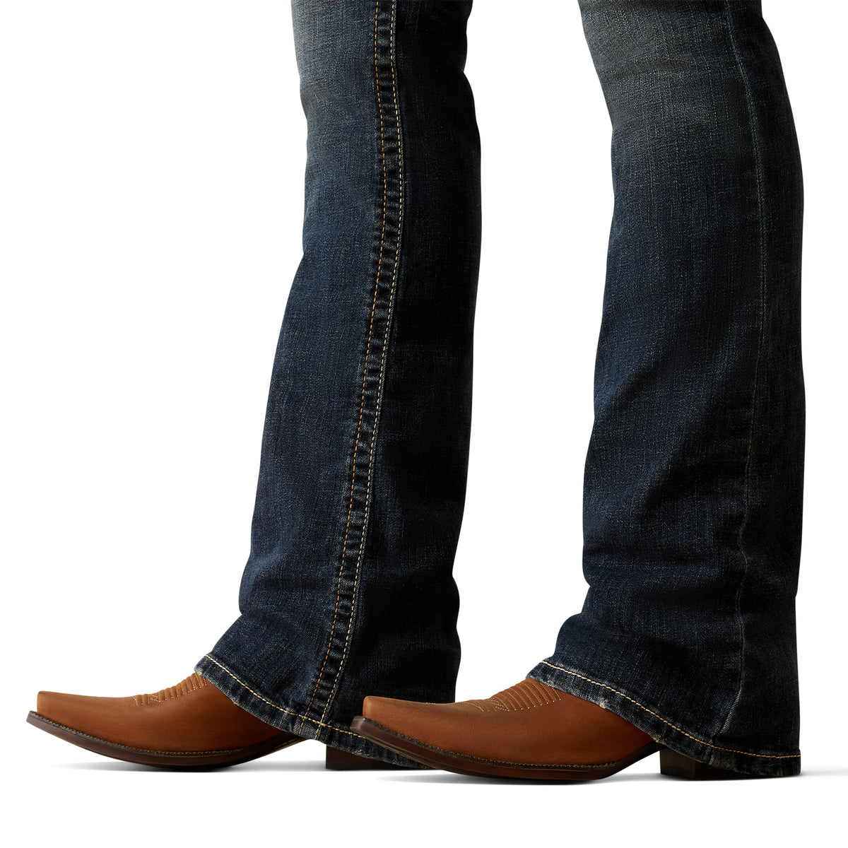 Ariat Women's Lilla Mid Rise Boot Cut Jean. Close-up of blue jeans and brown cowboy boots on a white background