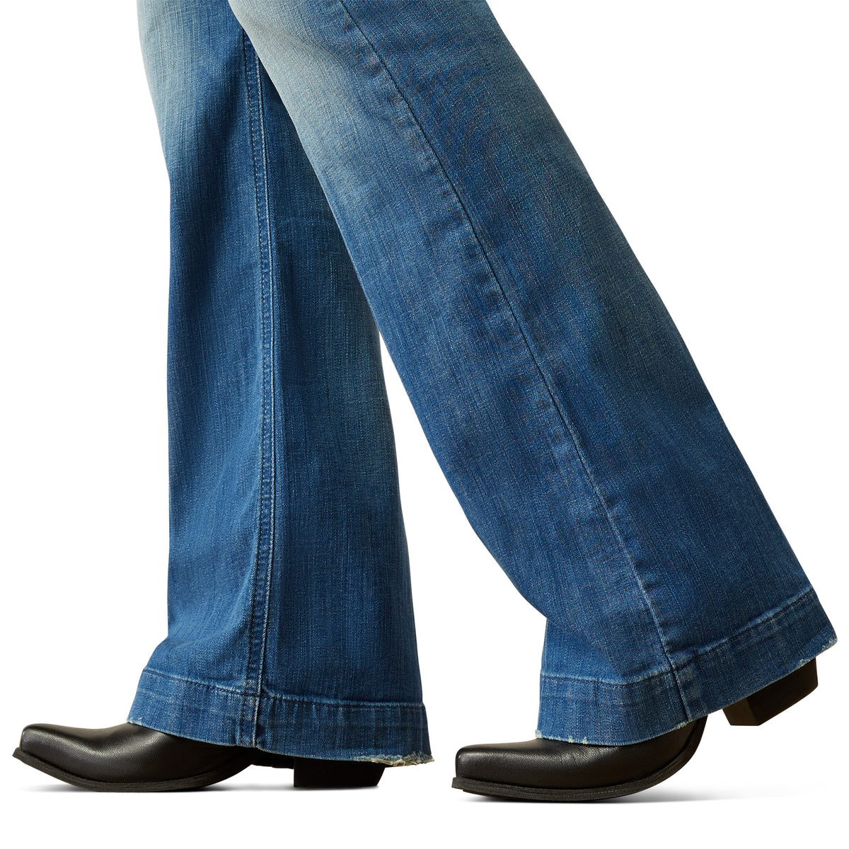 Ariat Women's Elaina High Rise Slim Trouser Jean. Close-up of blue jeans and black shoes on a white background