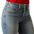 Ariat Women's Cecilia High Rise Boot Cut Jean. Close-up of blue jeans with a red shirt underneath on a white background