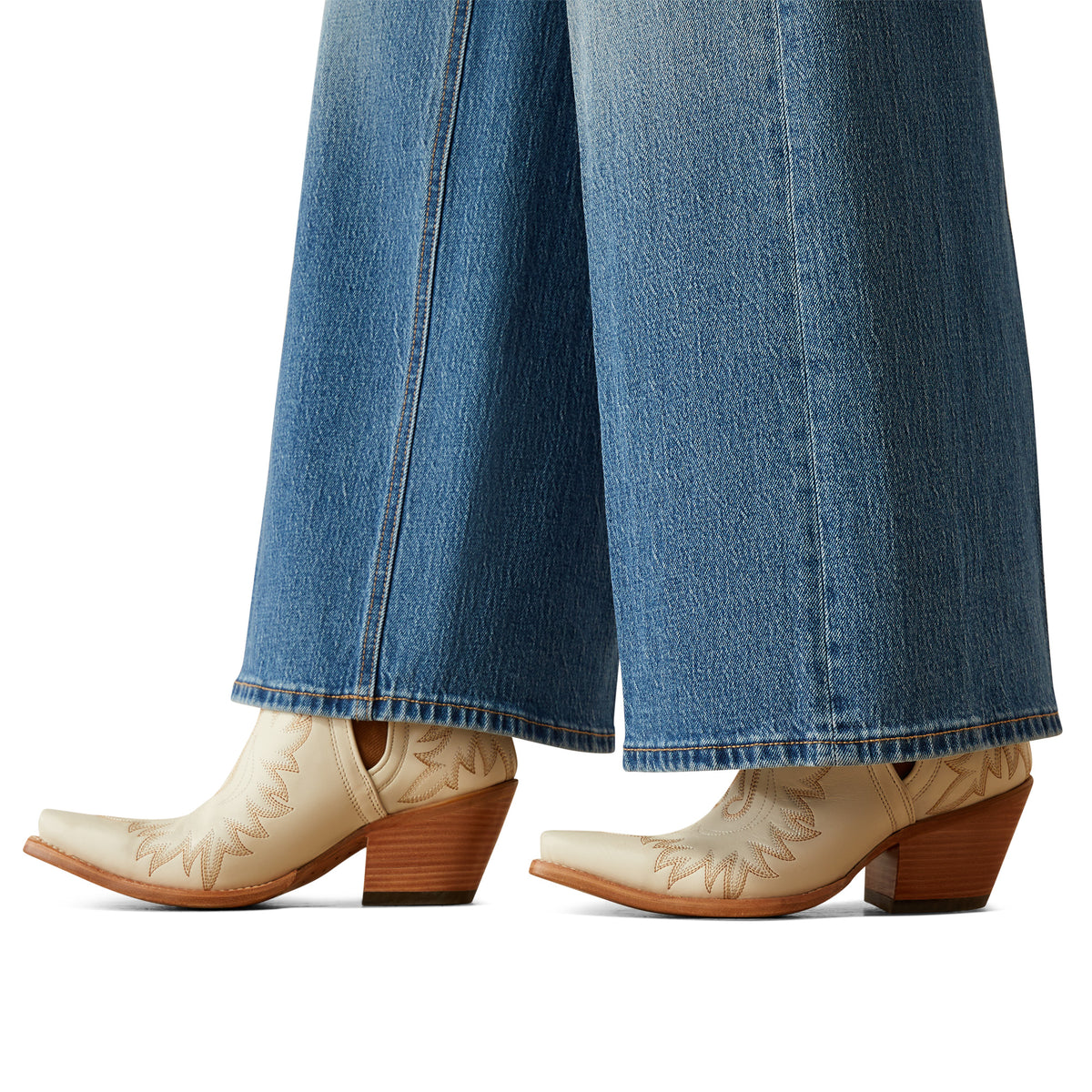 Ariat Women's Jazmine Ultra High-Rise Wide Leg Jean. Beige cowboy boots with brown soles worn with blue jeans on a white background