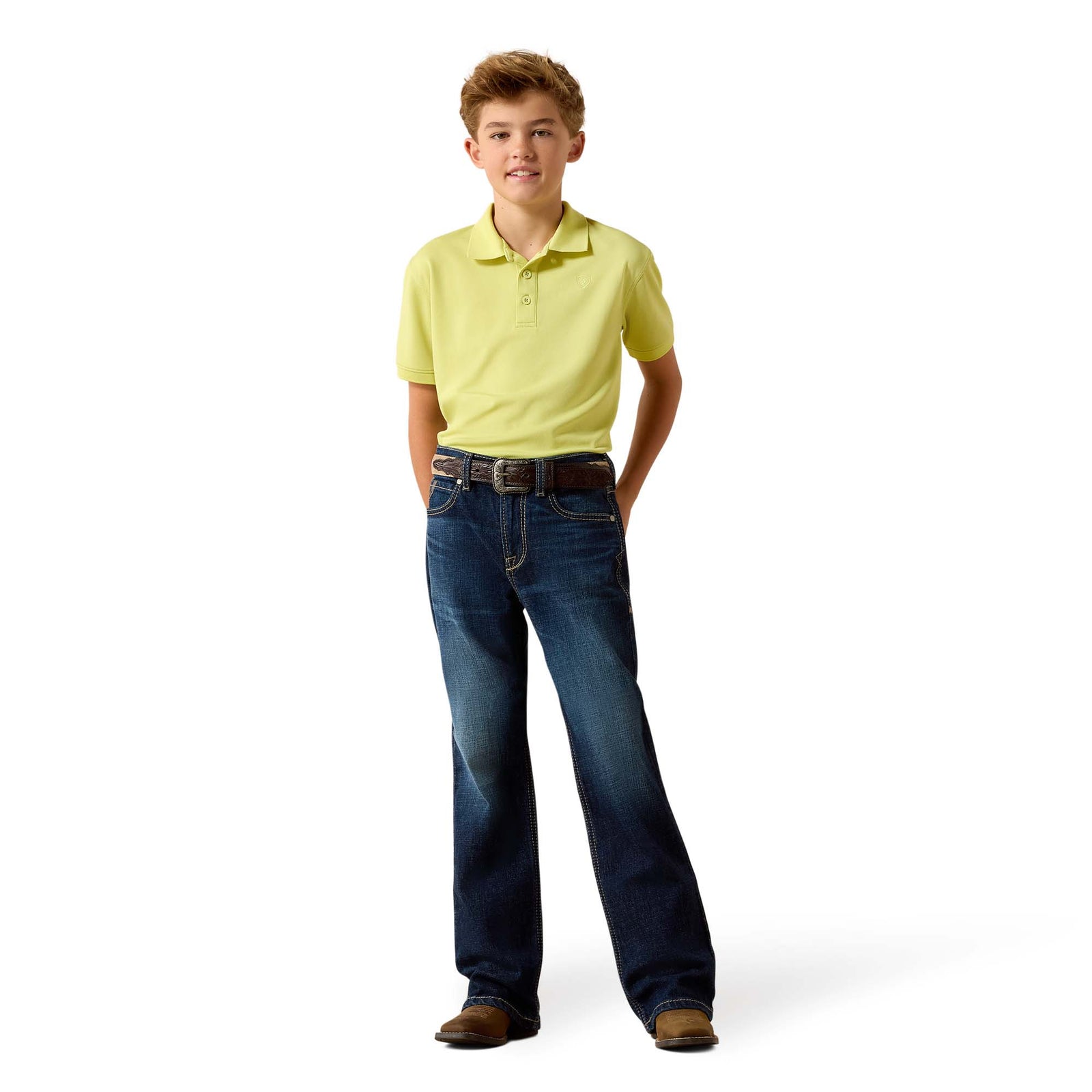 Young boy wearing a yellow polo shirt and blue jeans on a white background