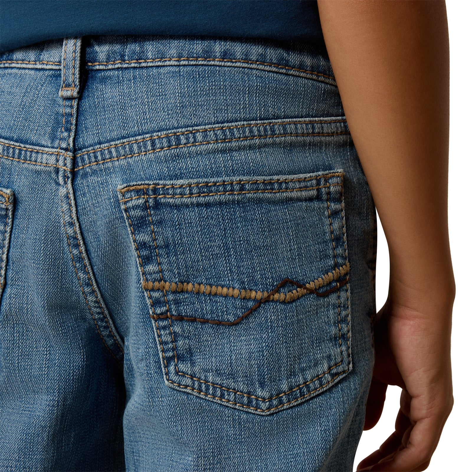 Close-up of blue jeans with a pocket detail on a white background