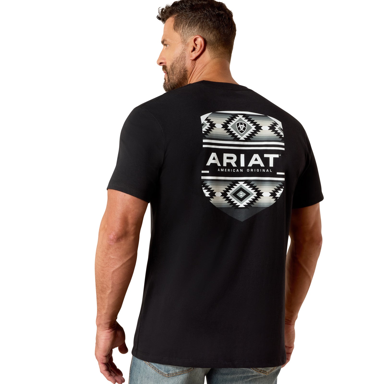 Man wearing a black Ariat t-shirt with a geometric design on the back against a white background
