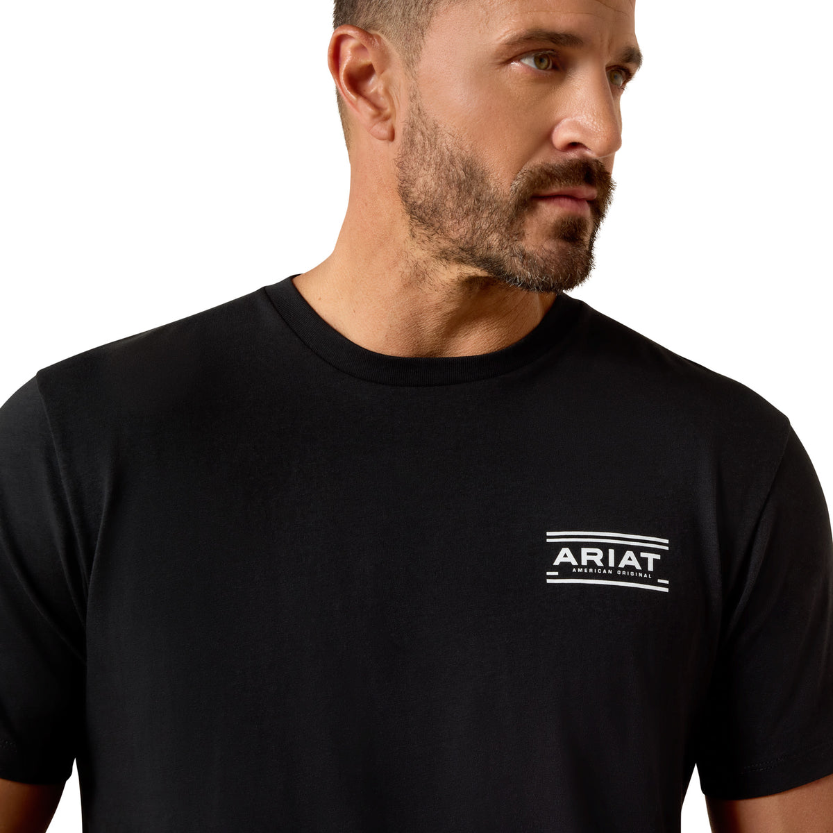 Man wearing a black t-shirt with Ariat logo on a white background