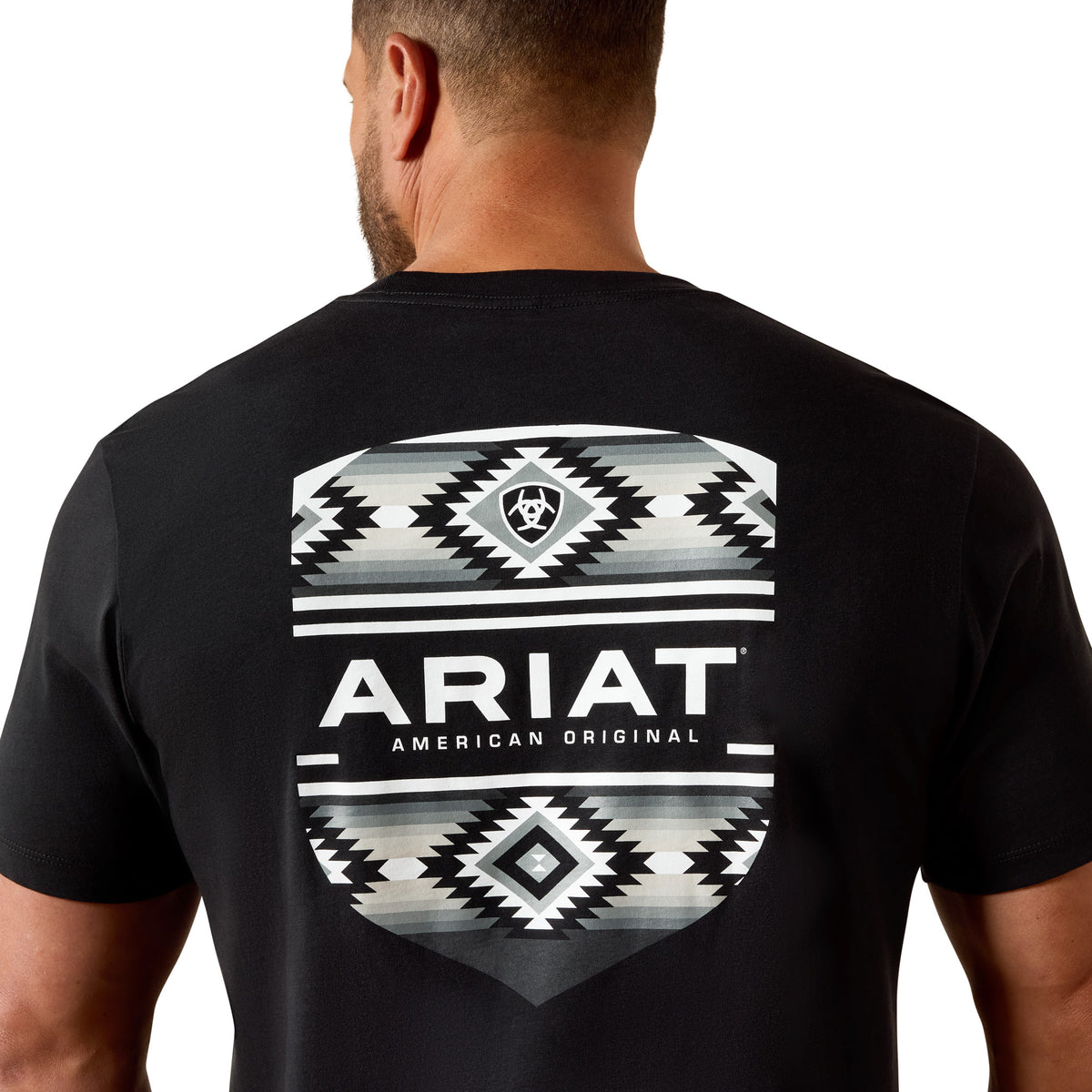 Man wearing a black Ariat t-shirt with a geometric pattern on the back