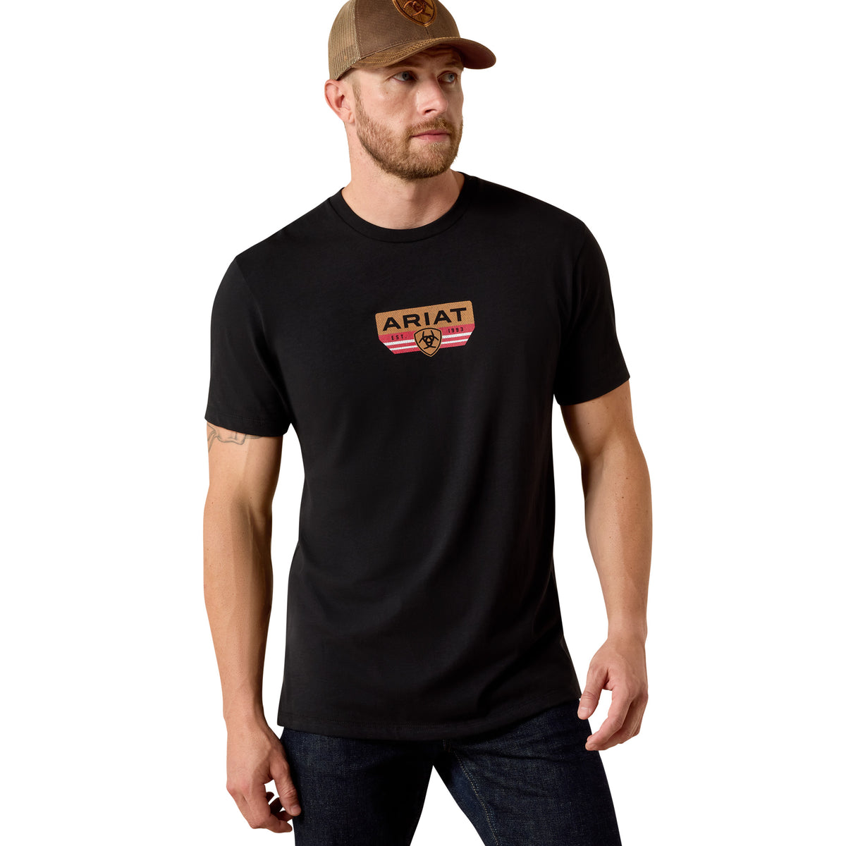 Man wearing a black t-shirt with Ariat logo and a brown cap on a white background