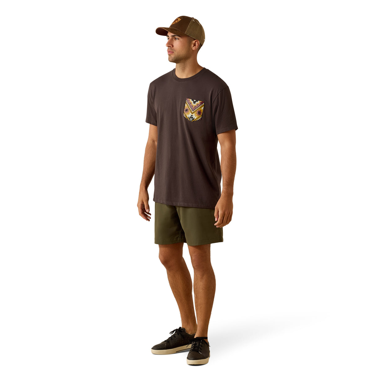 Man wearing a brown t-shirt with a pocket design and green shorts on a white background