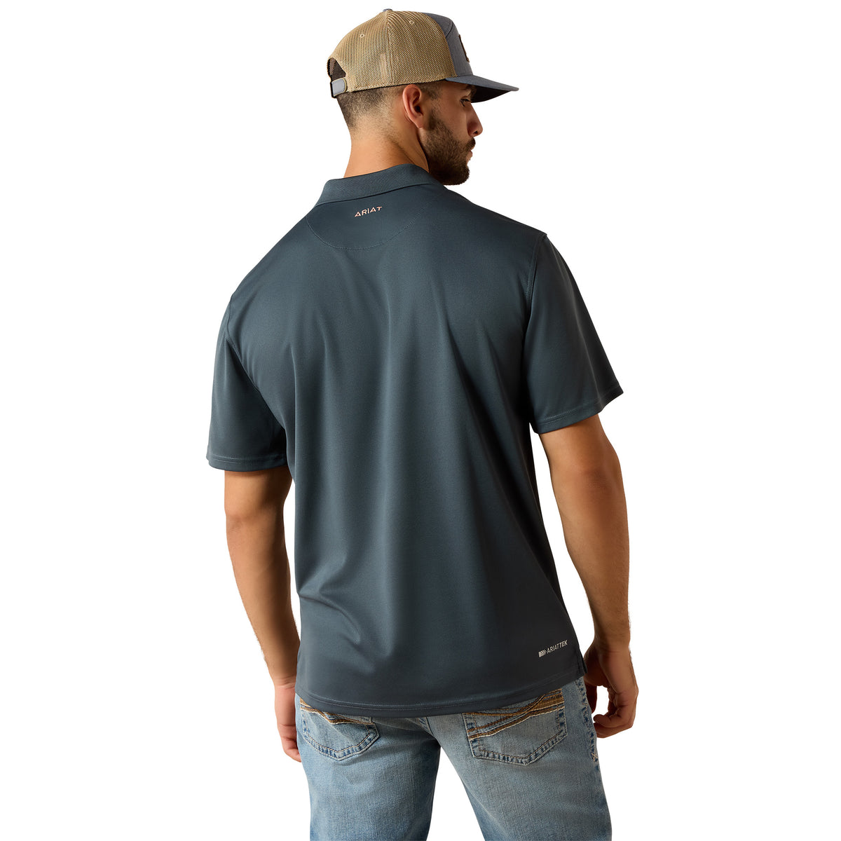 A man wearing a dark slate blue short-sleeve polo shirt from the back, paired with a tan and gray trucker hat and light blue jeans, against a plain white background.