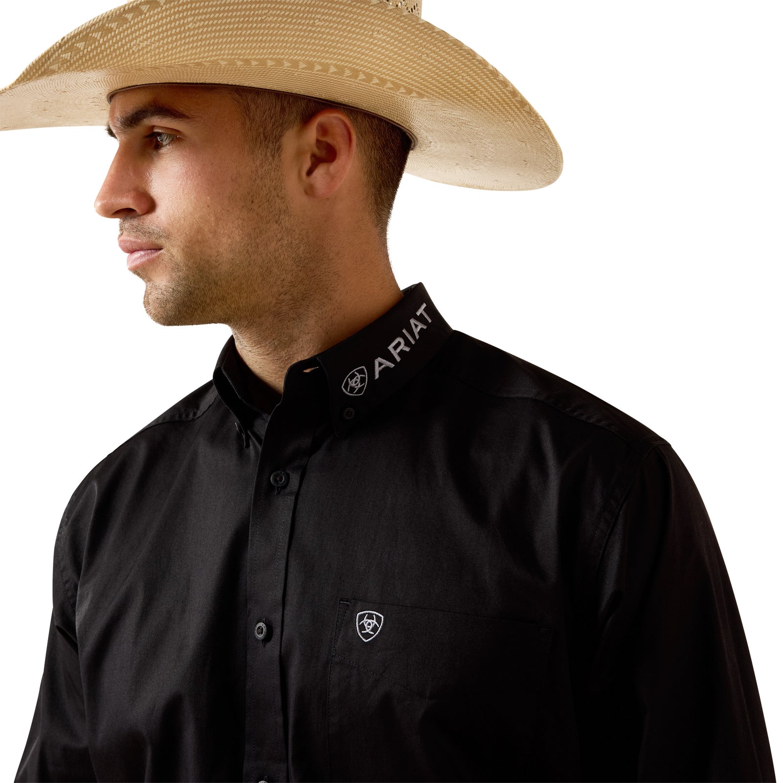 Man wearing a black Ariat shirt and straw hat on a white background