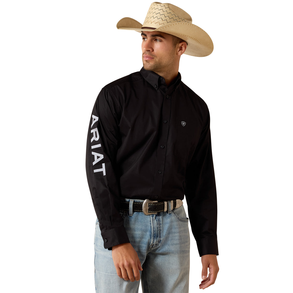 Man wearing a black Ariat shirt, light blue jeans, and a straw cowboy hat on a white background