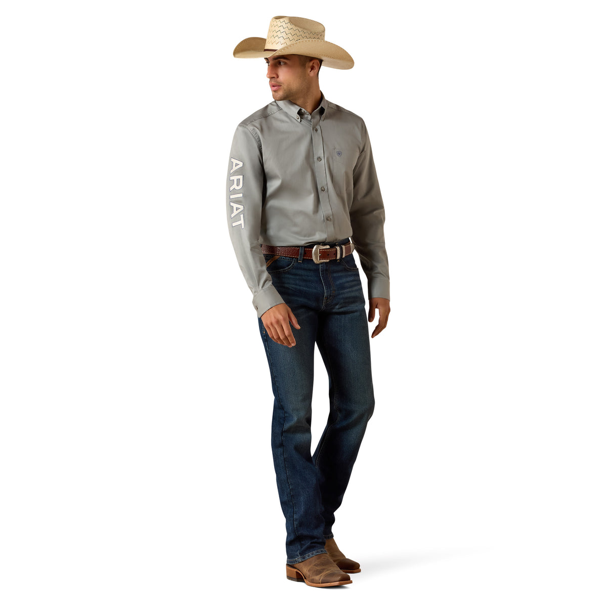 Man wearing a gray Ariat shirt, blue jeans, and a straw hat on a white background