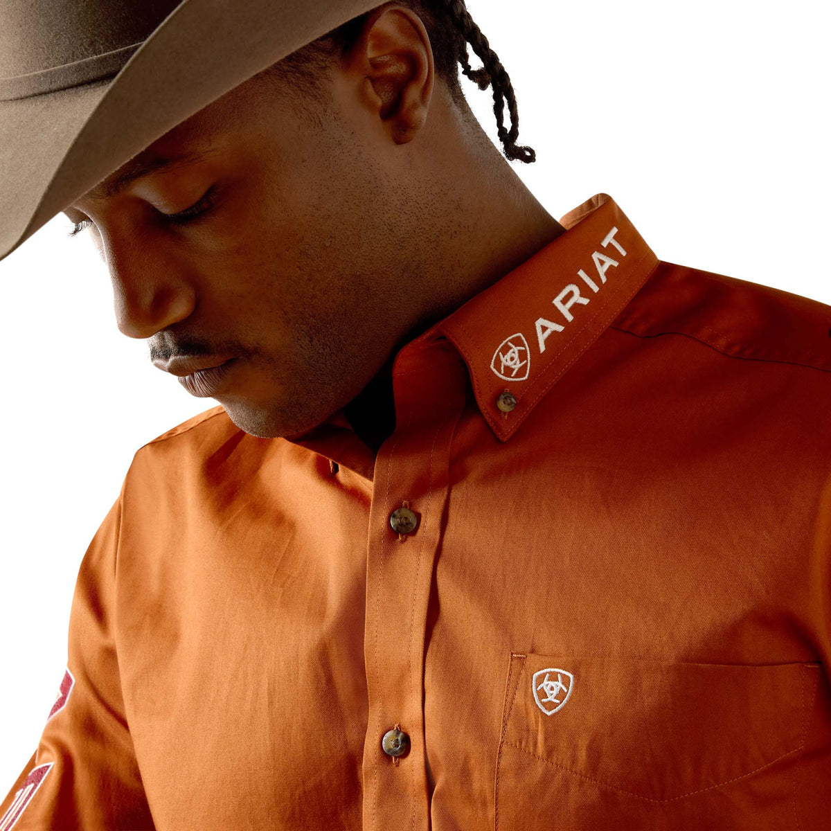 Person wearing an Ariat shirt with a neutral background