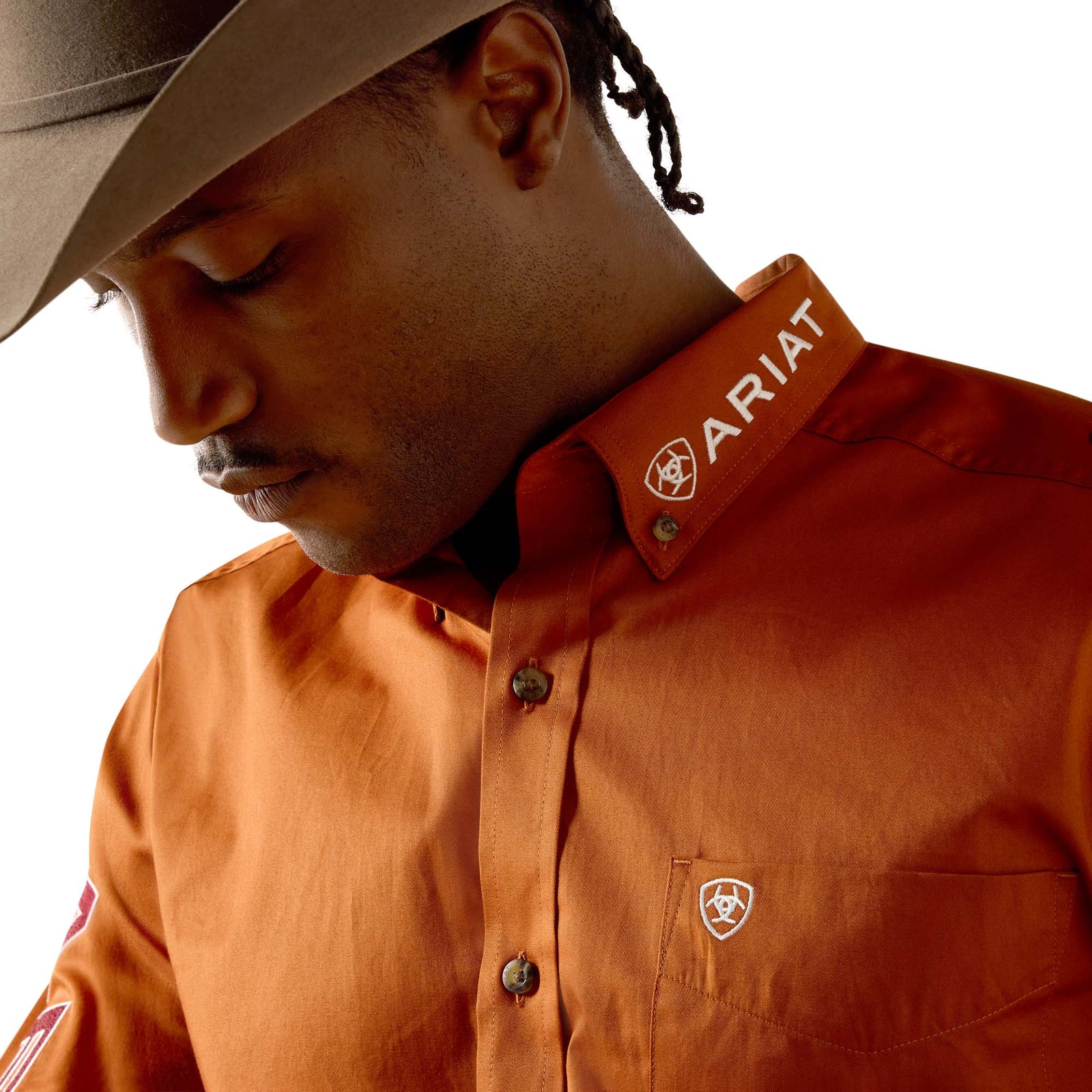 Person wearing an Ariat shirt with a neutral background