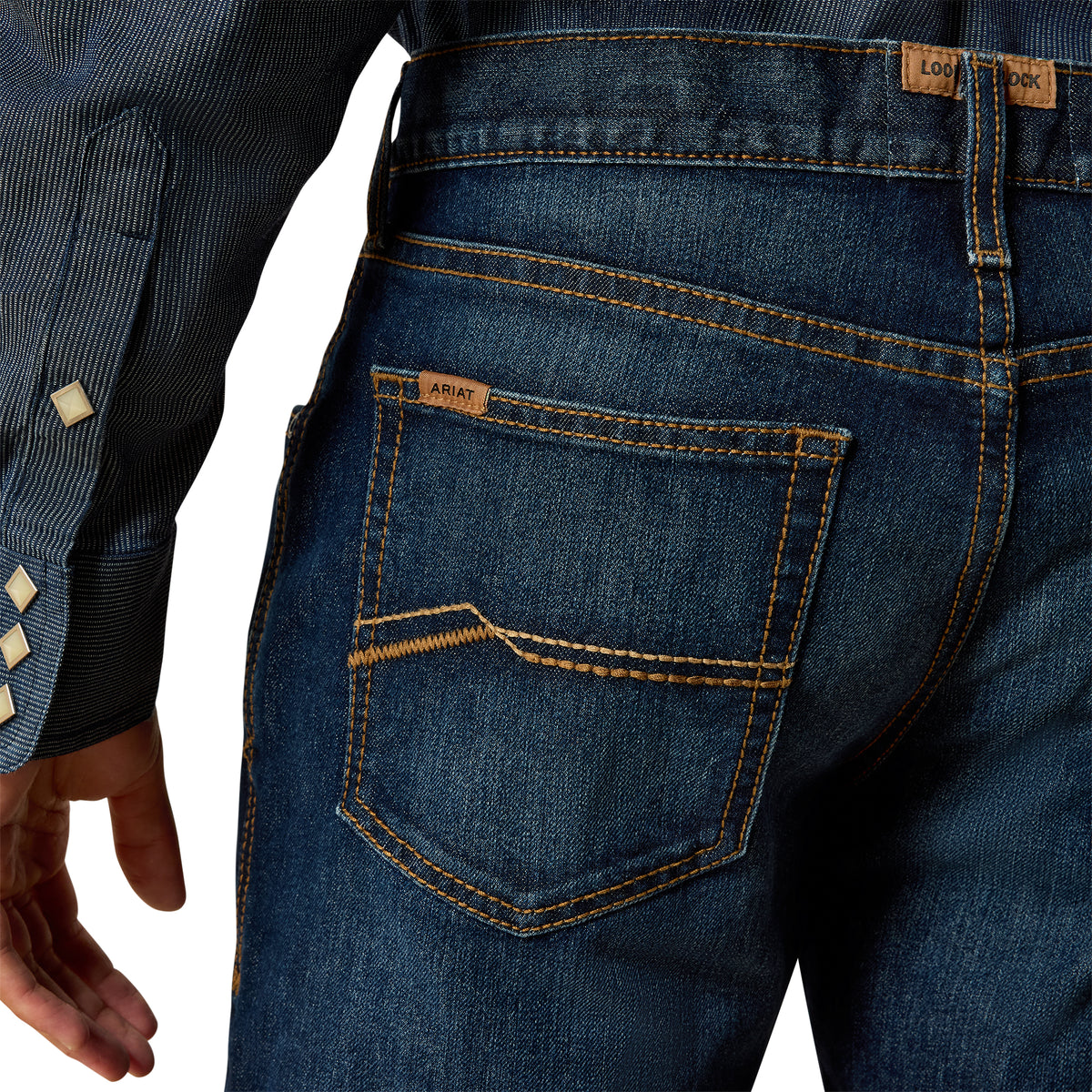 Close-up of blue jeans with a visible brand label on a white background