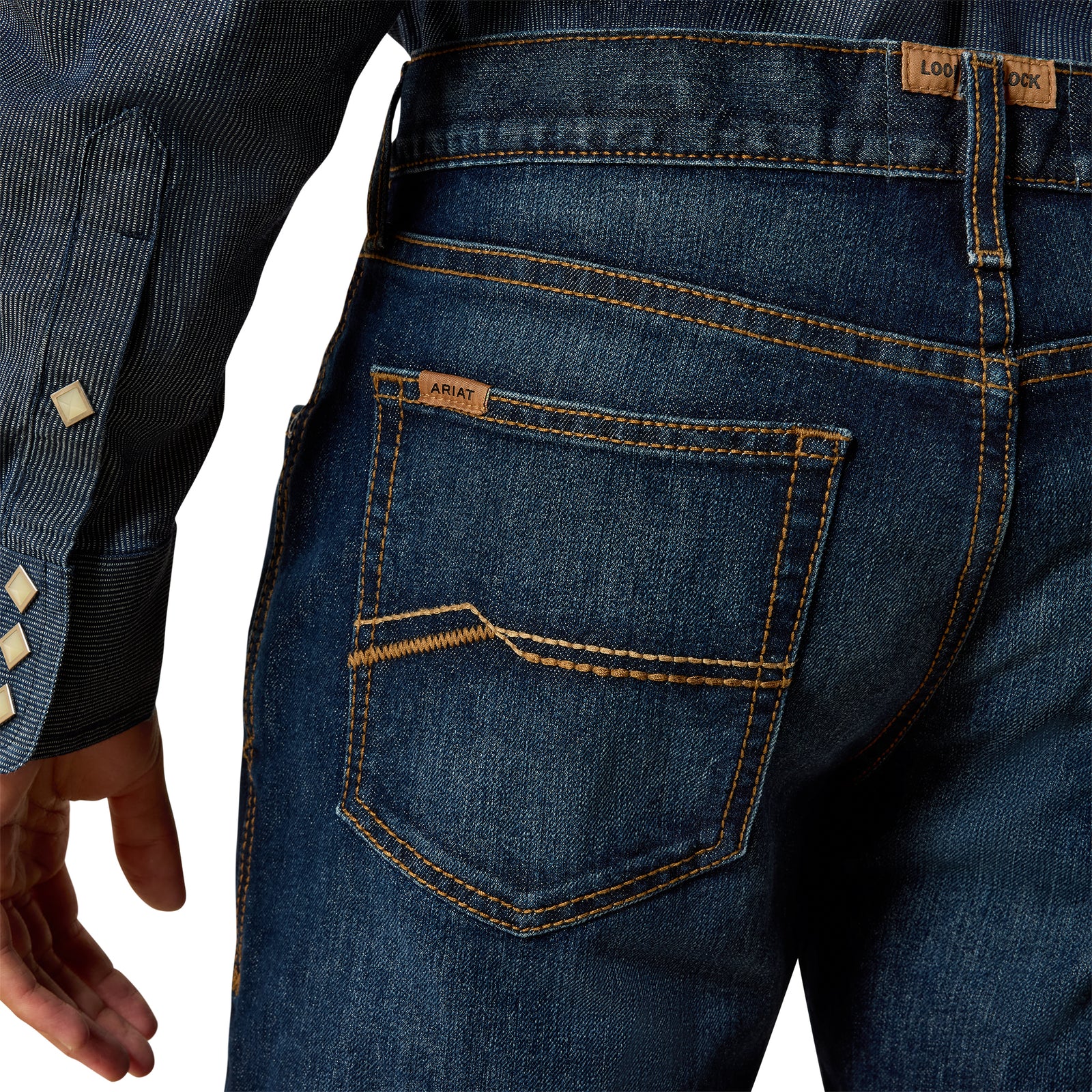 Close-up of blue jeans with a visible brand label on a white background