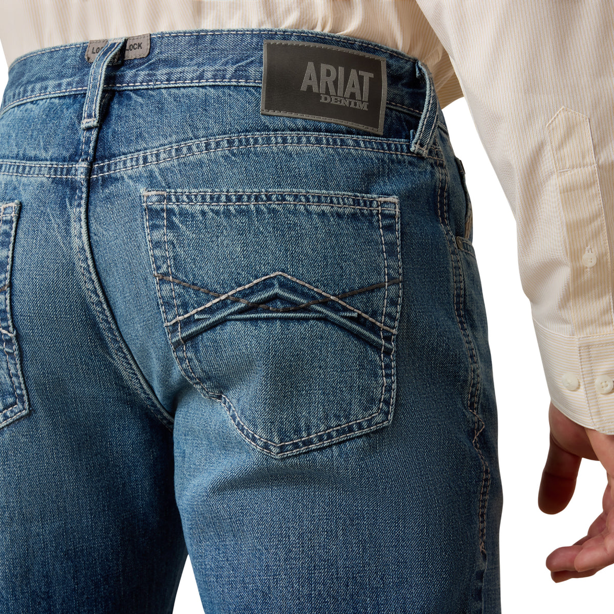 Blue jeans with Ariat logo on the back pocket against a white background