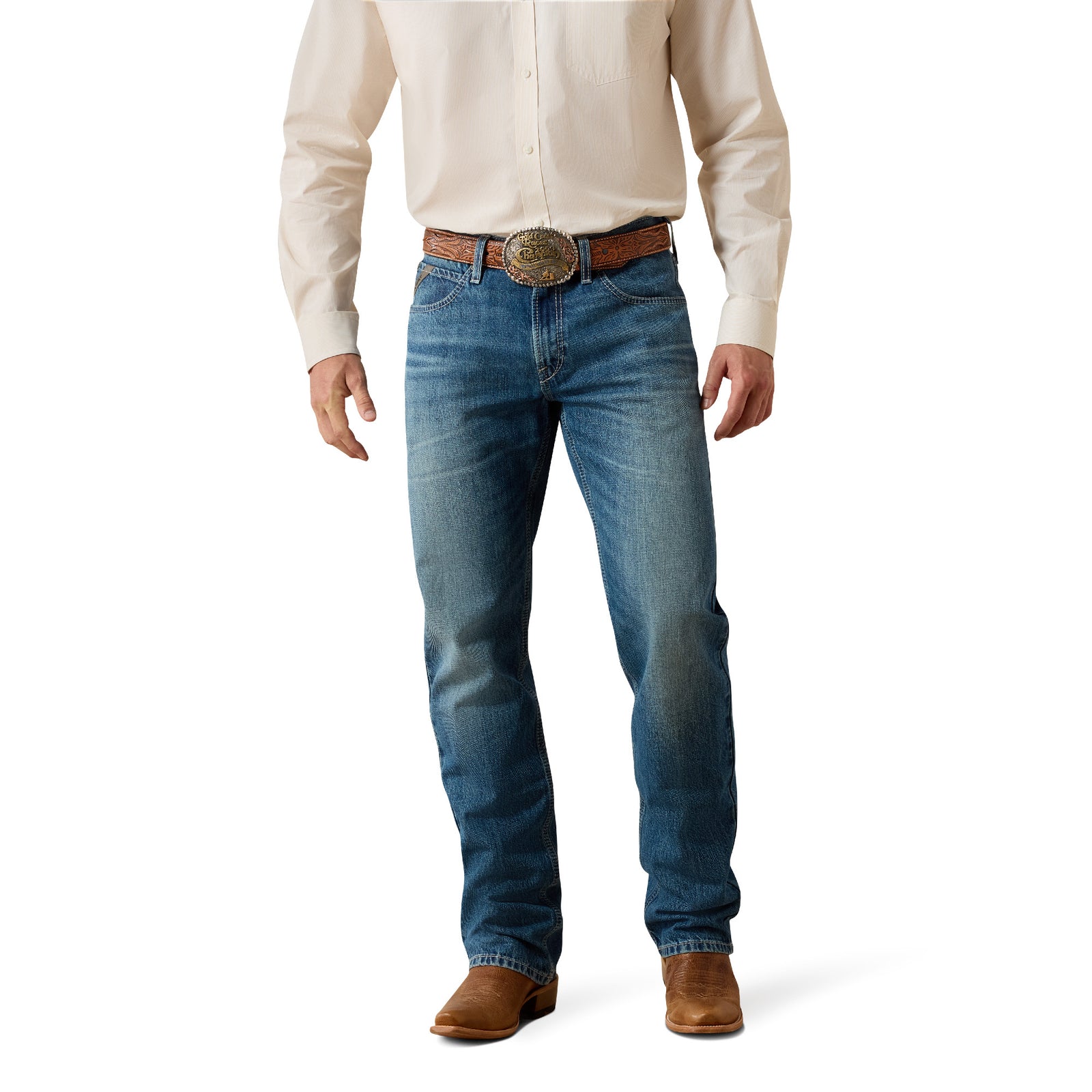 Man wearing a beige shirt, blue jeans, and brown boots on a white background