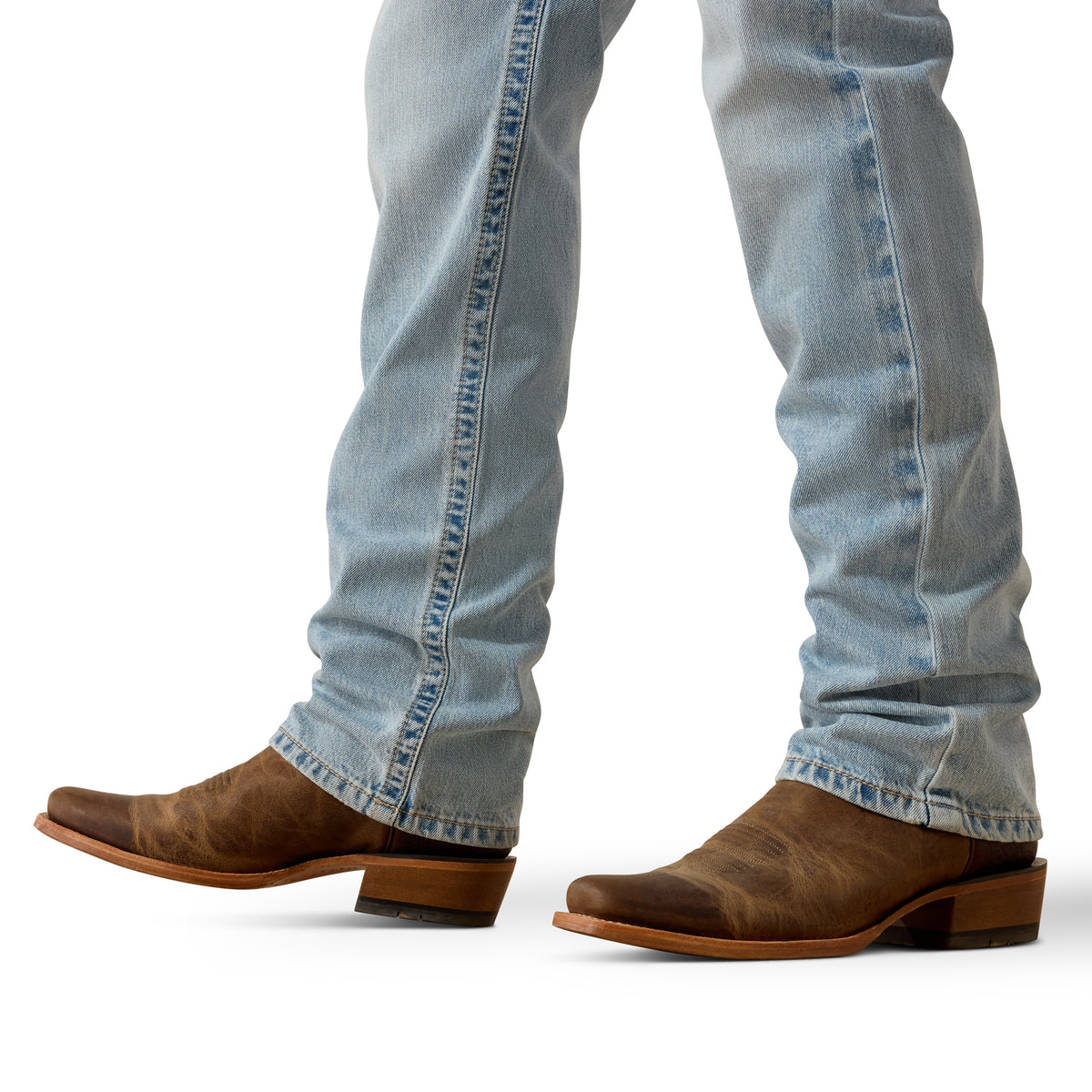 Close-up of blue jeans and brown cowboy boots on a white background