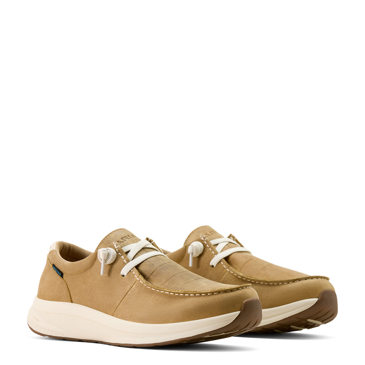 Pair of tan sneakers with white laces on a white background