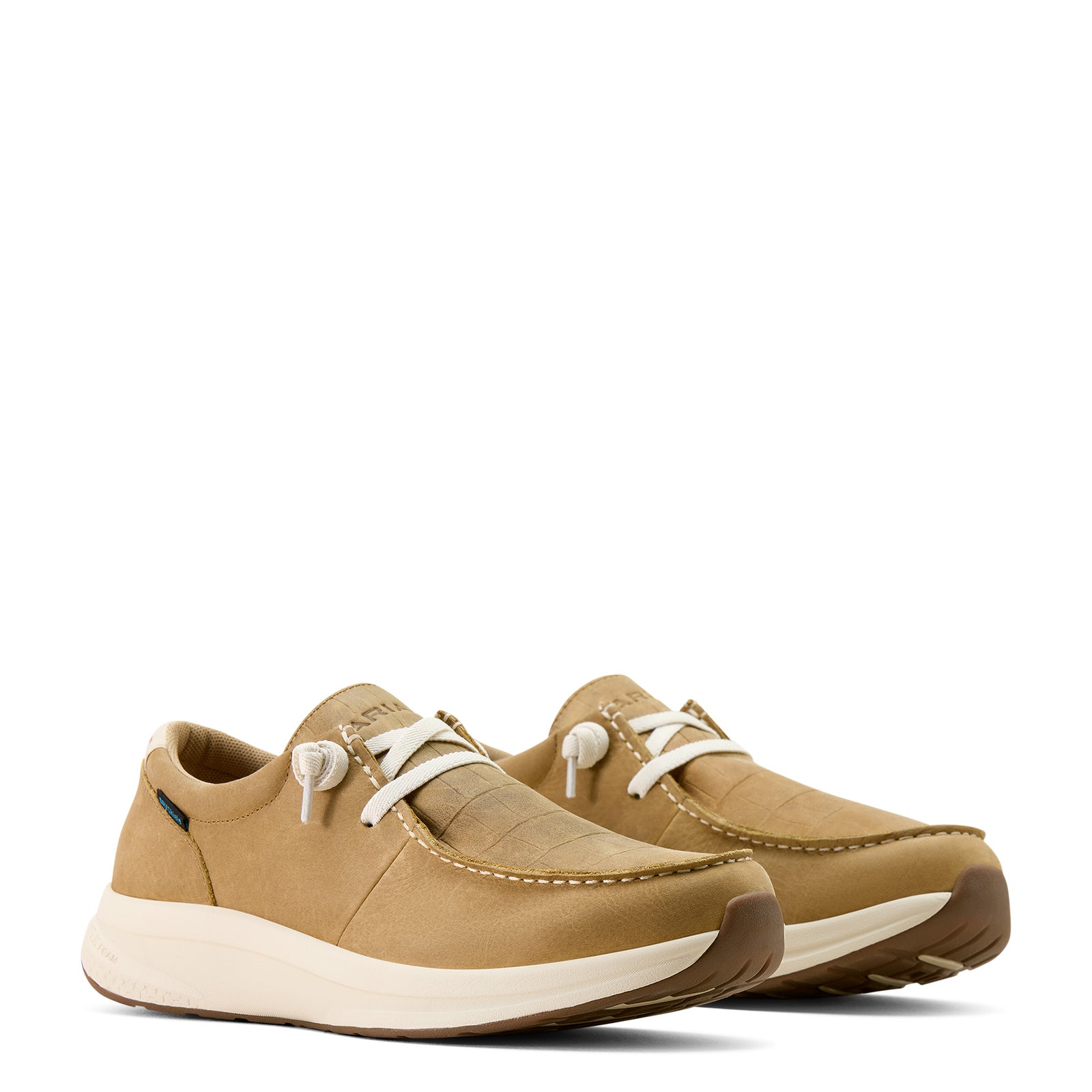 Pair of tan sneakers with white laces on a white background