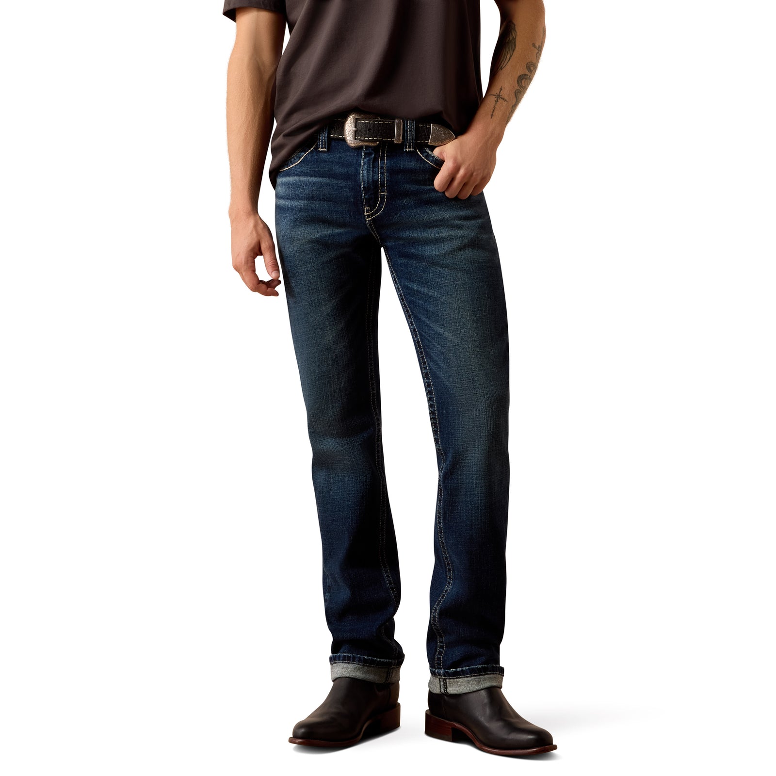 Person wearing blue jeans and brown shoes on a white background