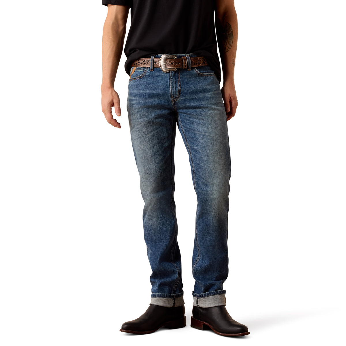 Person wearing blue jeans and black shoes on a white background