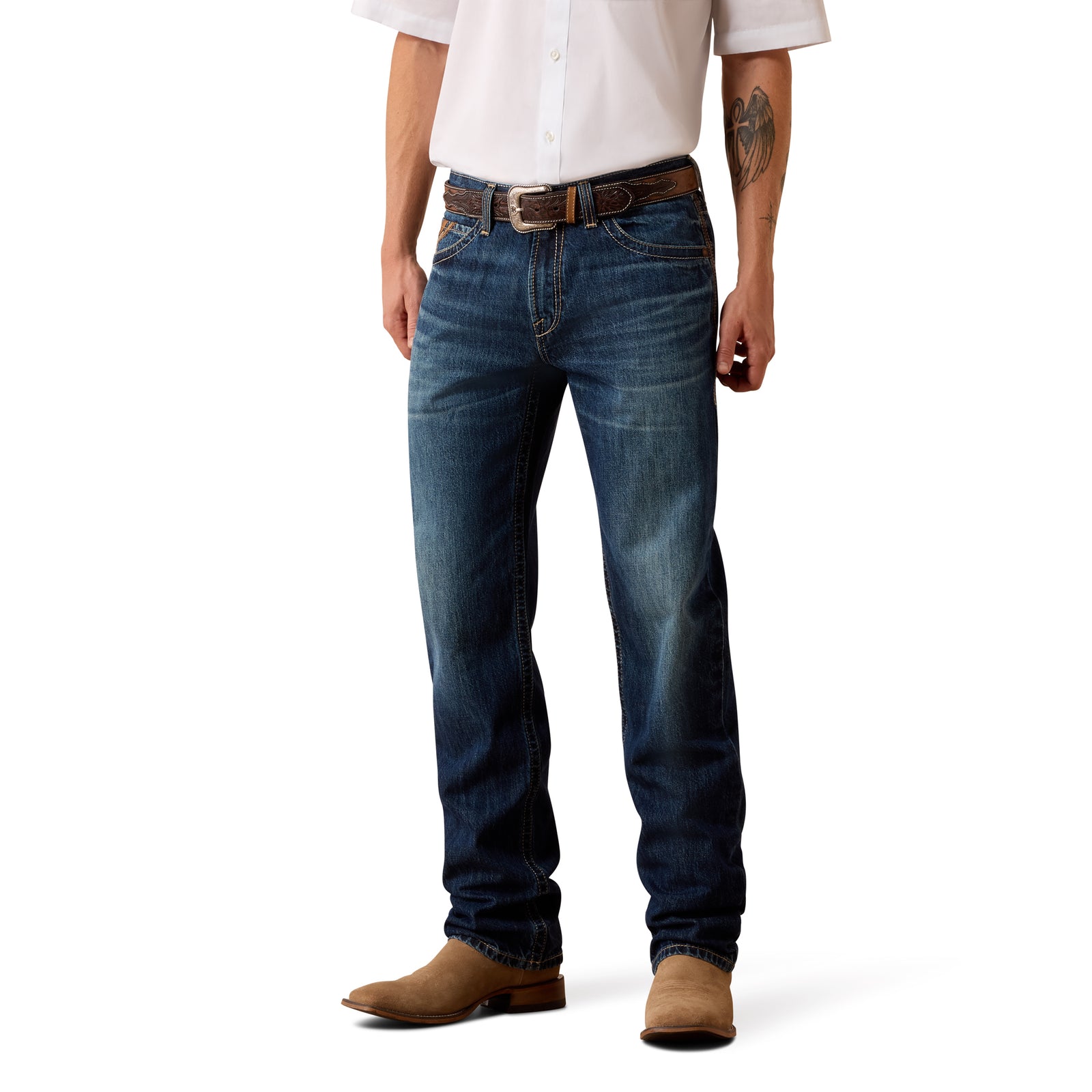 A man wearing dark blue denim jeans, a brown leather belt, a white button-down shirt, and brown suede boots, shown from the waist down on a white studio background.