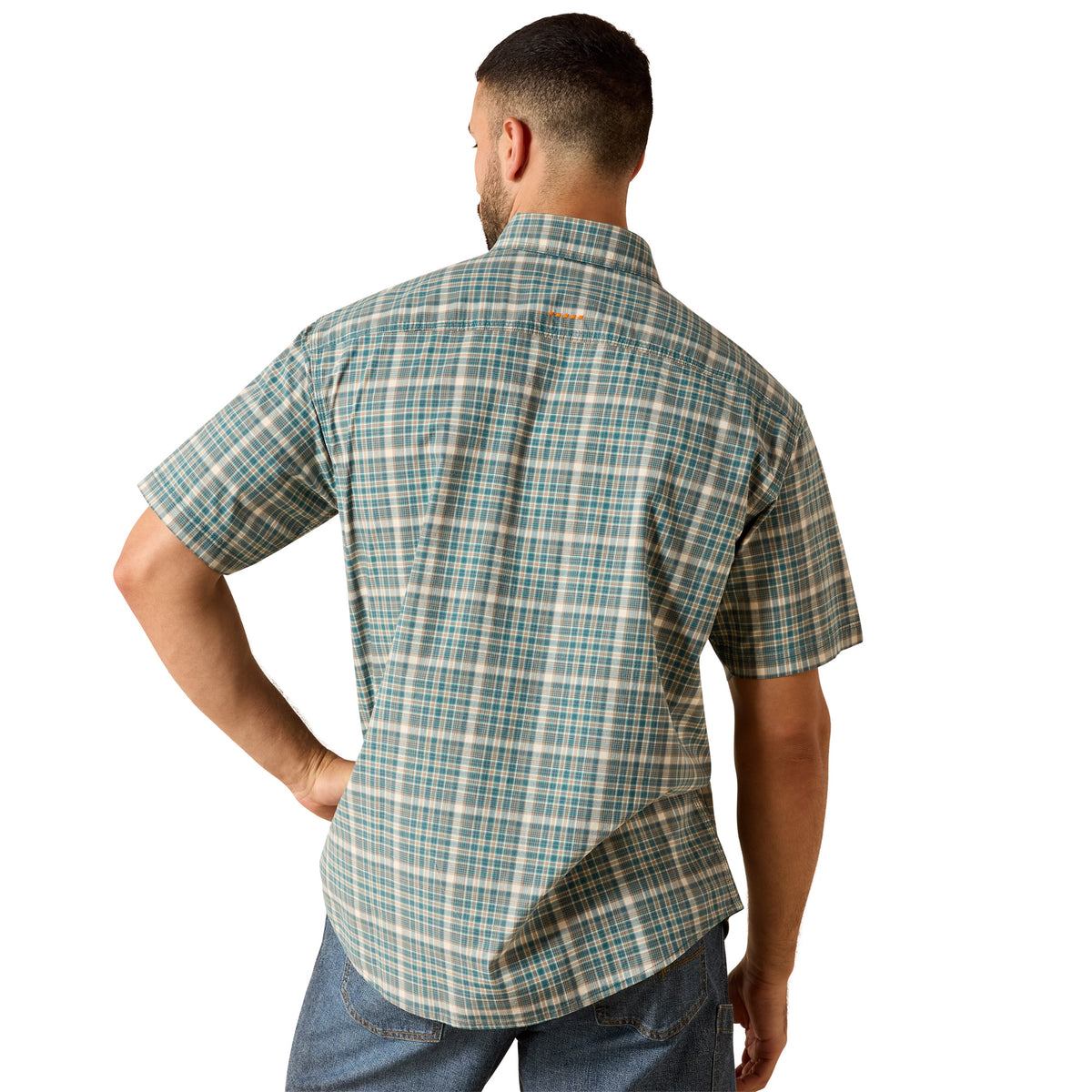 A man viewed from the back wearing a short-sleeve plaid button-up shirt in teal, beige, and white, paired with blue jeans against a plain white background.