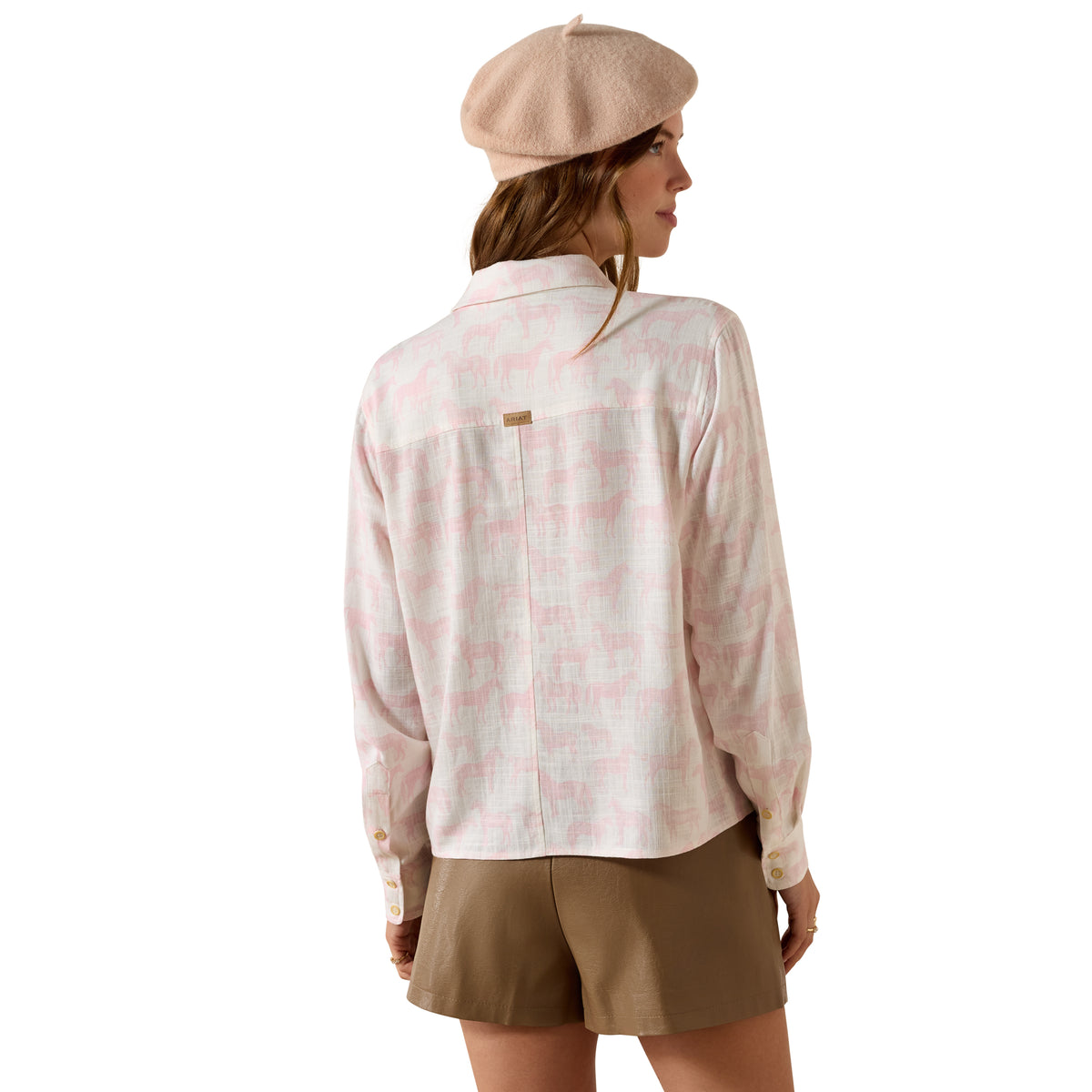 Woman wearing a patterned shirt and beige beret on a white background