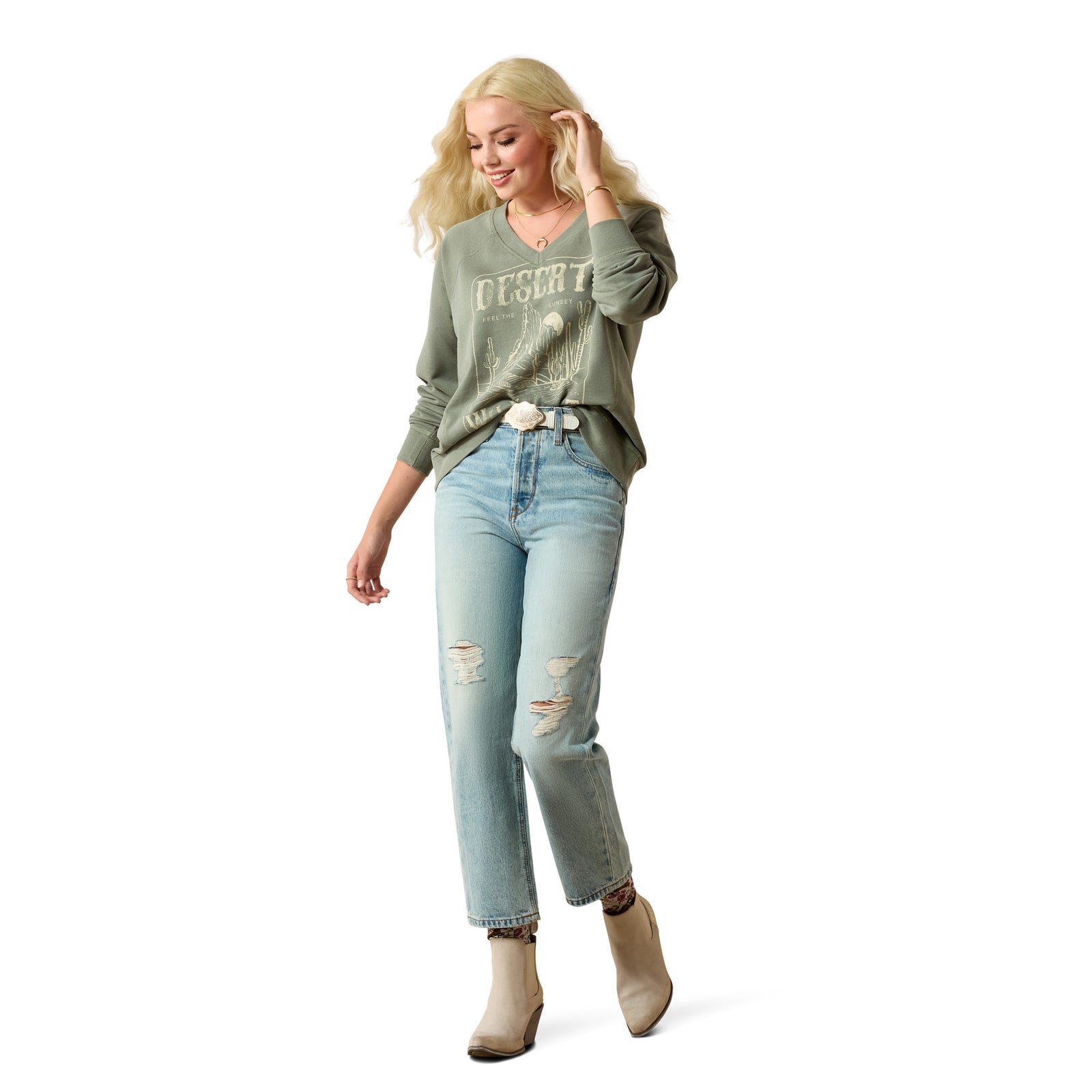 Woman wearing a green sweatshirt with text and light blue jeans on a white background