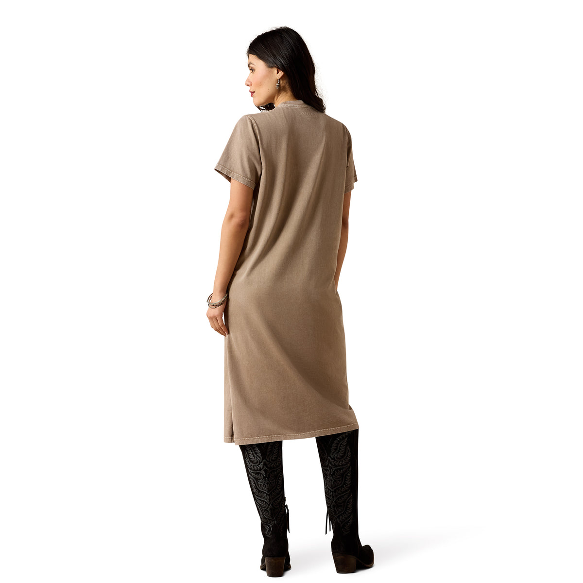 A woman shown from the back wearing a loose, short-sleeve taupe-brown tunic dress, black patterned leggings, and dark brown boots against a plain white background.
