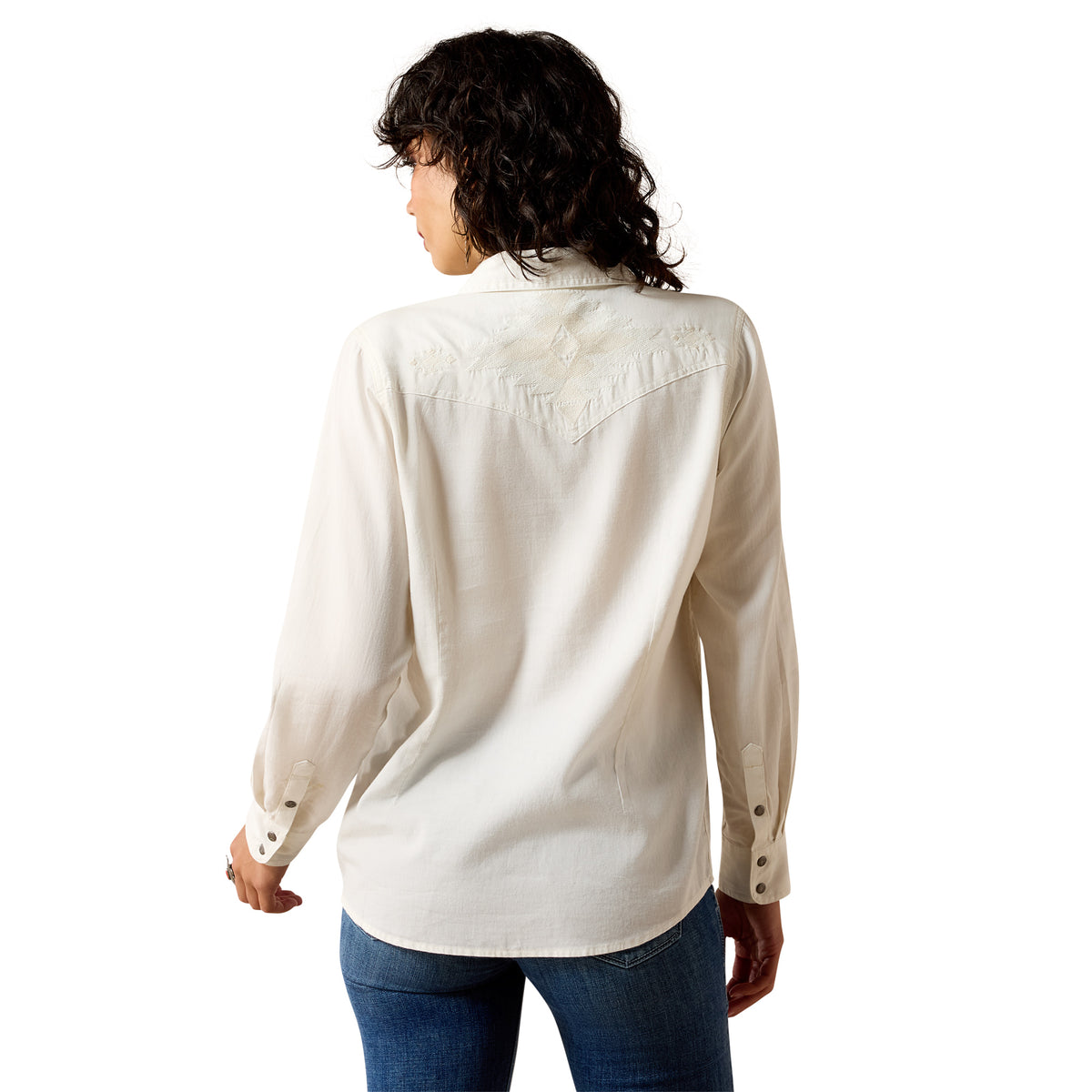 Person wearing a beige long-sleeve shirt and blue jeans on a white background